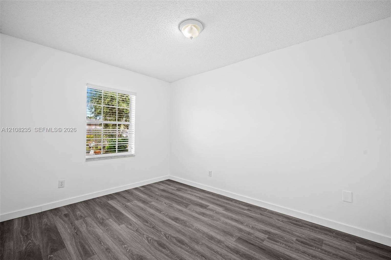 12752 SW 250th Terrace, Homestead, FL 33032 Room featuring wood-finish flooring, white walls, and a window with horizontal blinds