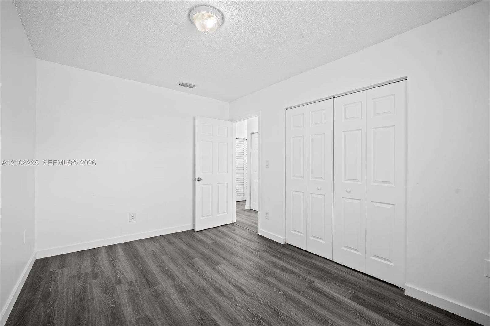 12752 SW 250th Terrace, Homestead, FL 33032 Neutral room featuring wood-finish flooring, double-panel closet doors, and a ceiling-mounted light fixture
