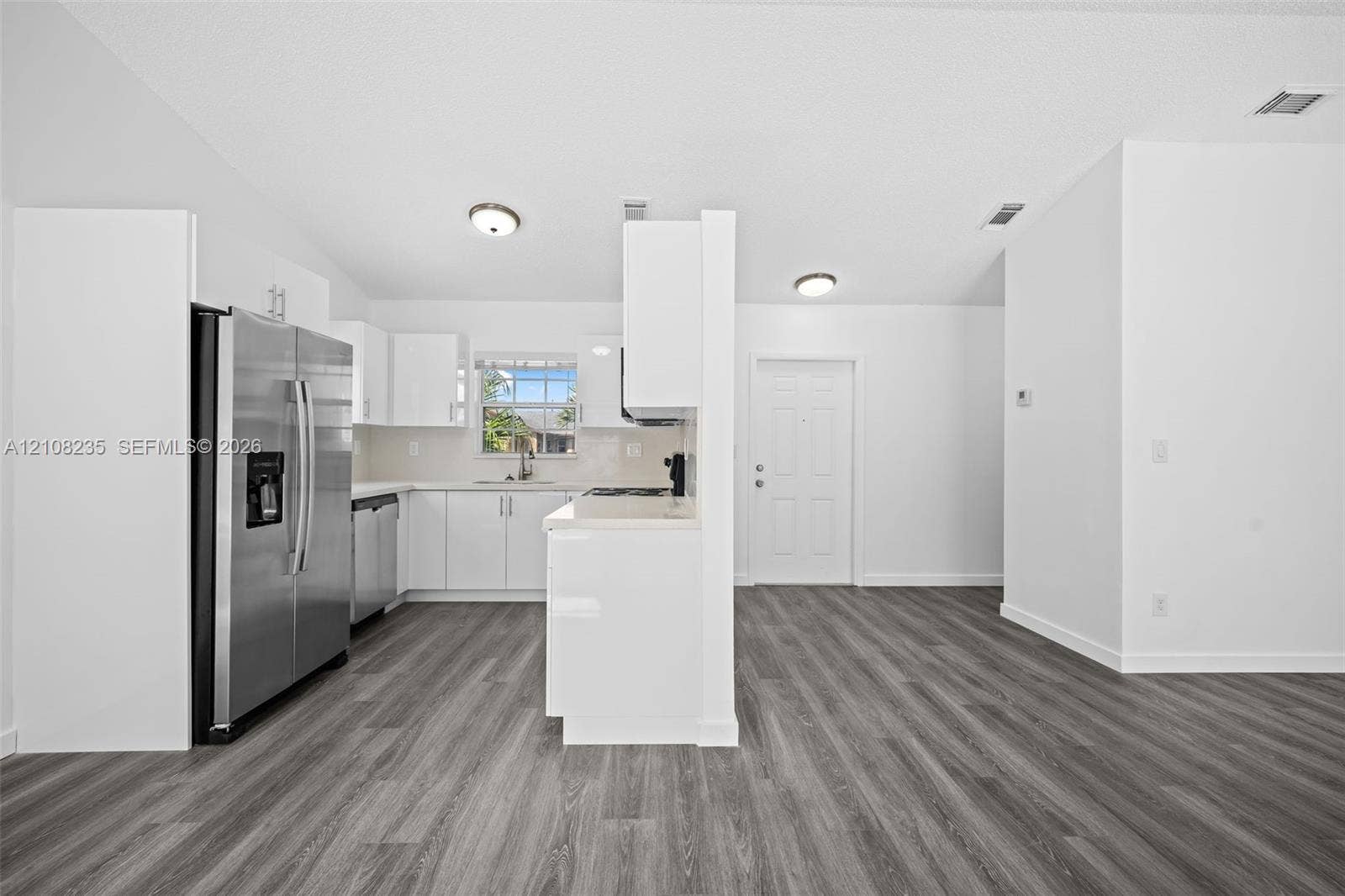 12752 SW 250th Terrace, Homestead, FL 33032 Kitchen featuring white cabinetry, wood-finish flooring, stainless steel side-by-side refrigerator, and a recessed window