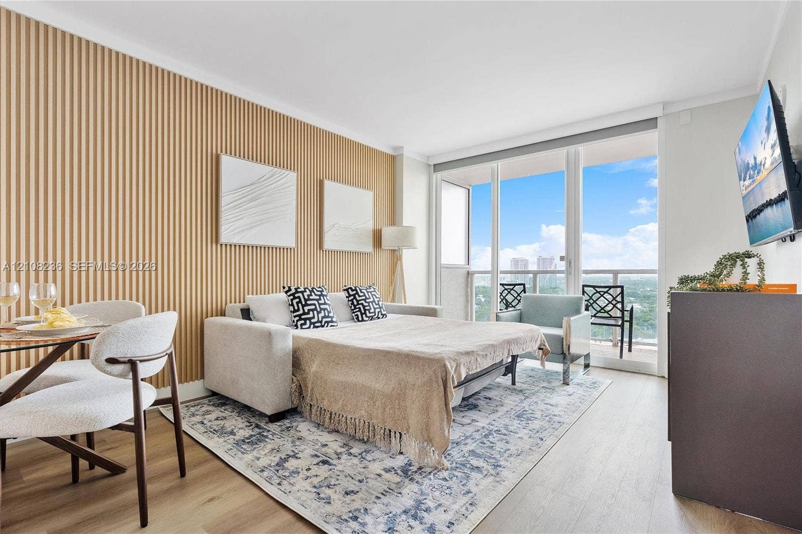 Living area featuring wood-slat accent wall, floor-to-ceiling glass sliding doors, and wood-finish flooring