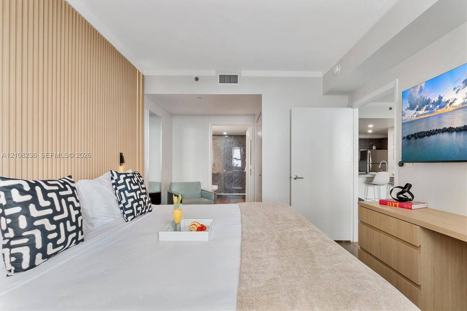 Interior space featuring a vertical slat wood-finish accent wall, neutral wall palette, and built-in wood-finish cabinetry