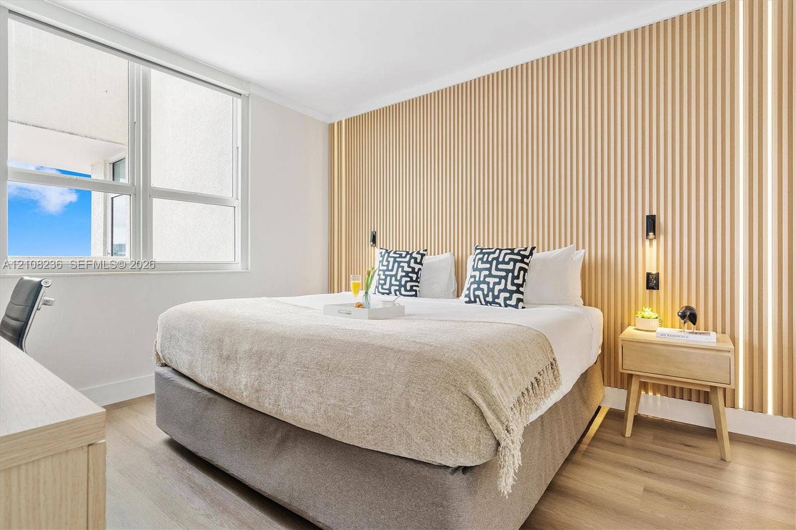 Textured wood-slat accent wall, integrated vertical LED strip lighting, large windows, and wood-finish flooring