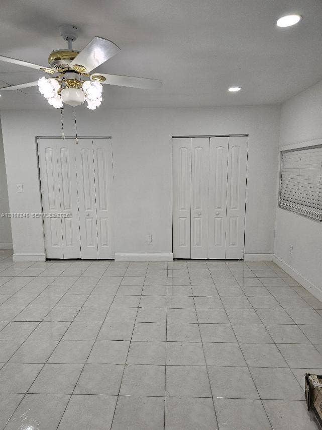Neutral-toned tile flooring, recessed ceiling lighting, multi-light ceiling fan, and two sets of interior bi-fold closet doors