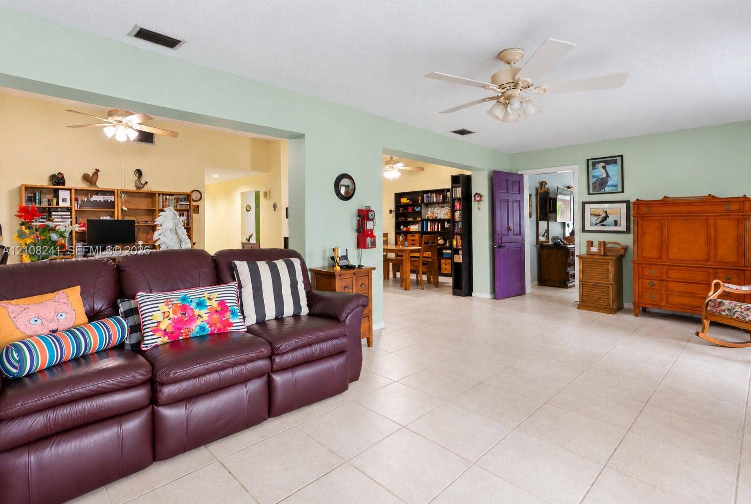 Neutral ceramic tile flooring, ceiling fans, and interior solid-core door