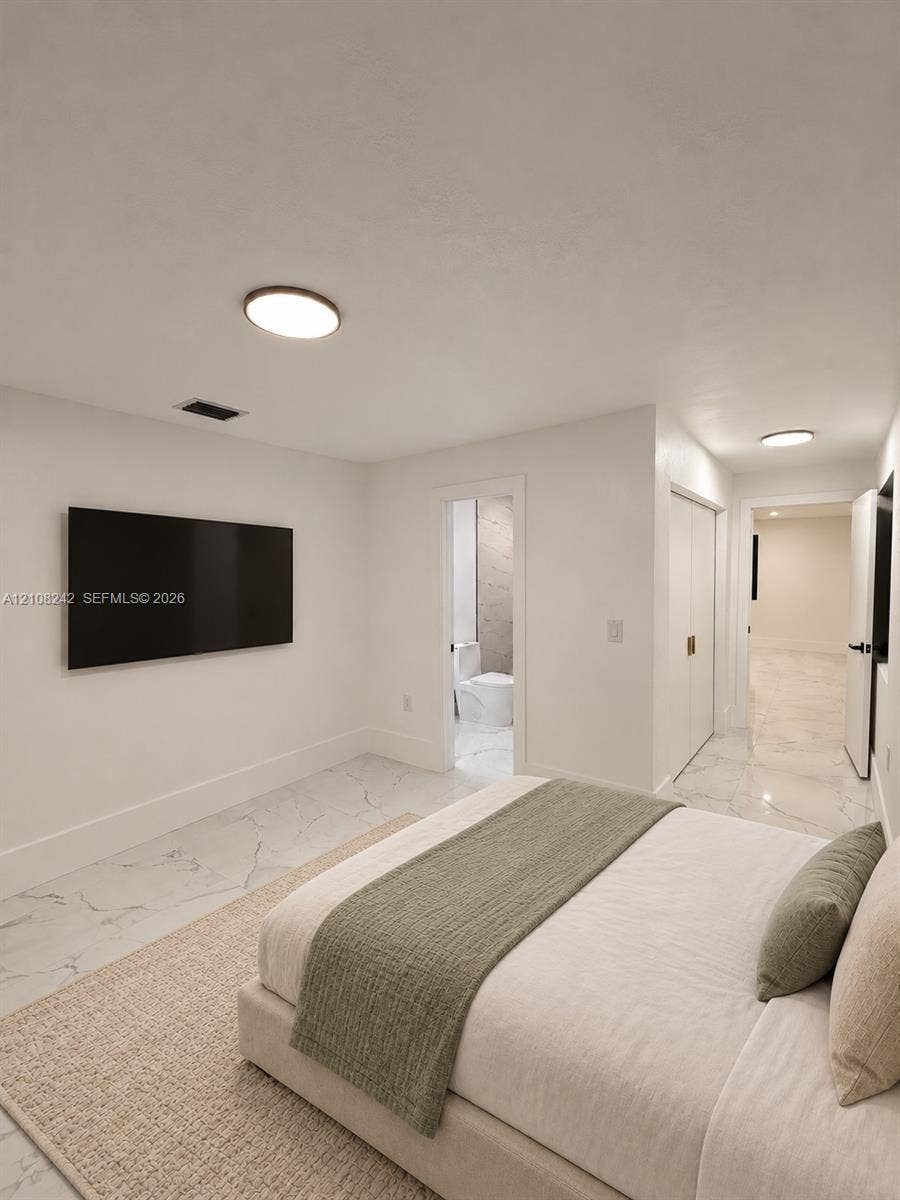 61 E 39th Street, Hialeah, FL 33013 Neutral-toned interior featuring large-format stone-finish tile flooring, flush-mount circular lighting, and double-door closet storage