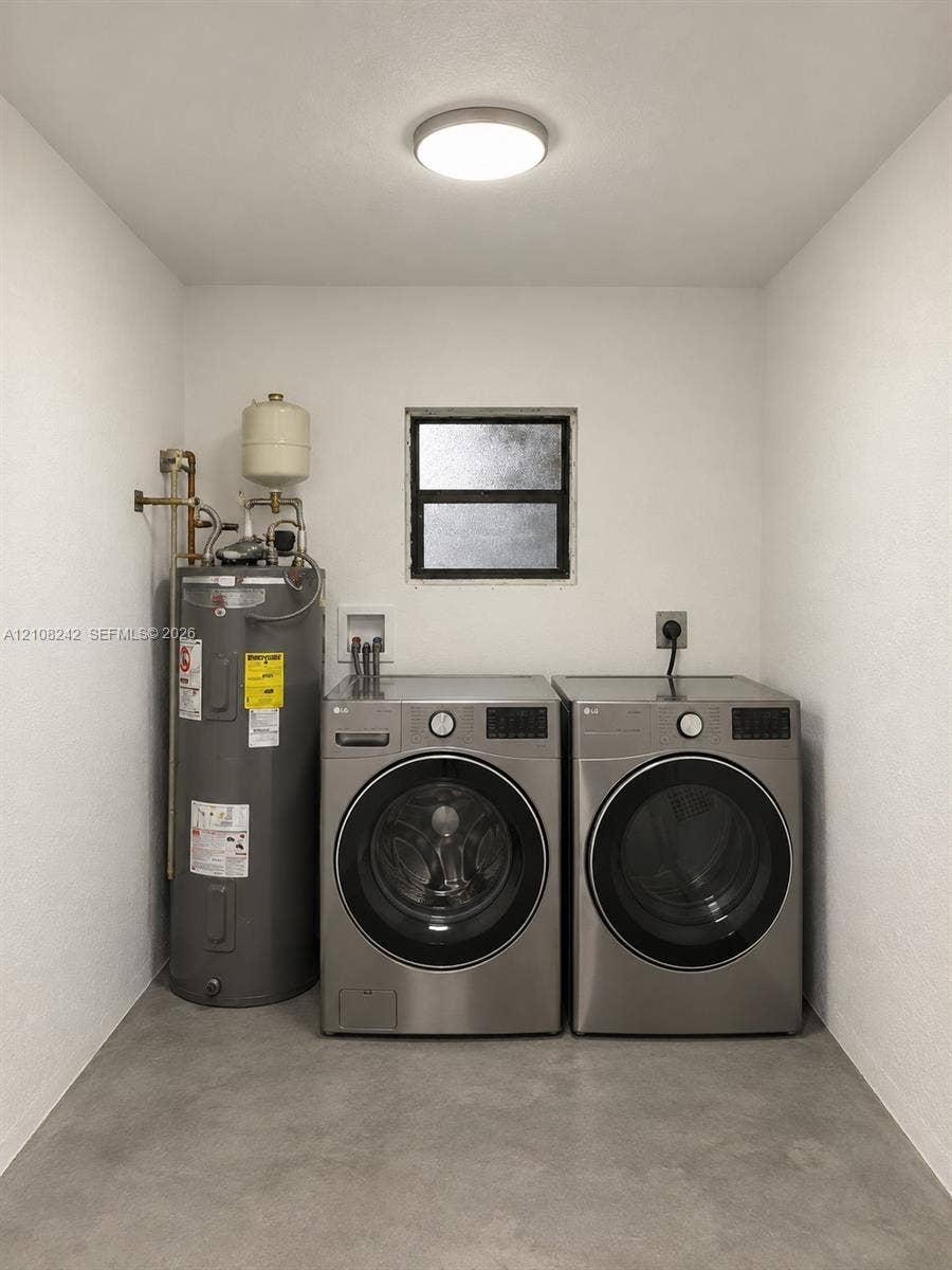 61 E 39th Street, Hialeah, FL 33013 Utility space featuring a water heater, dual-stackable appliance connections, a single-hung window, and concrete flooring