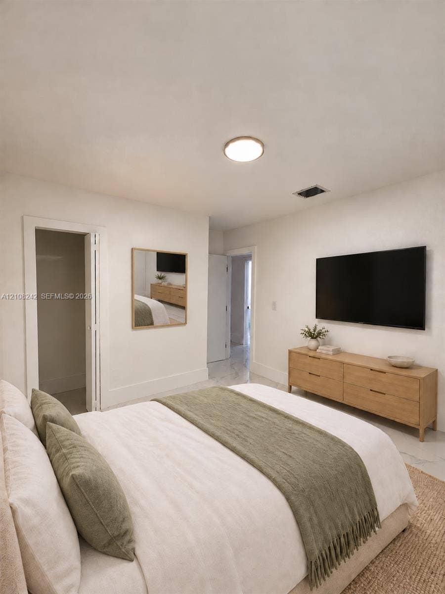 61 E 39th Street, Hialeah, FL 33013 Neutral interior featuring polished stone-finish flooring, recessed lighting, and a square wall-mounted mirror with a wood-tone frame