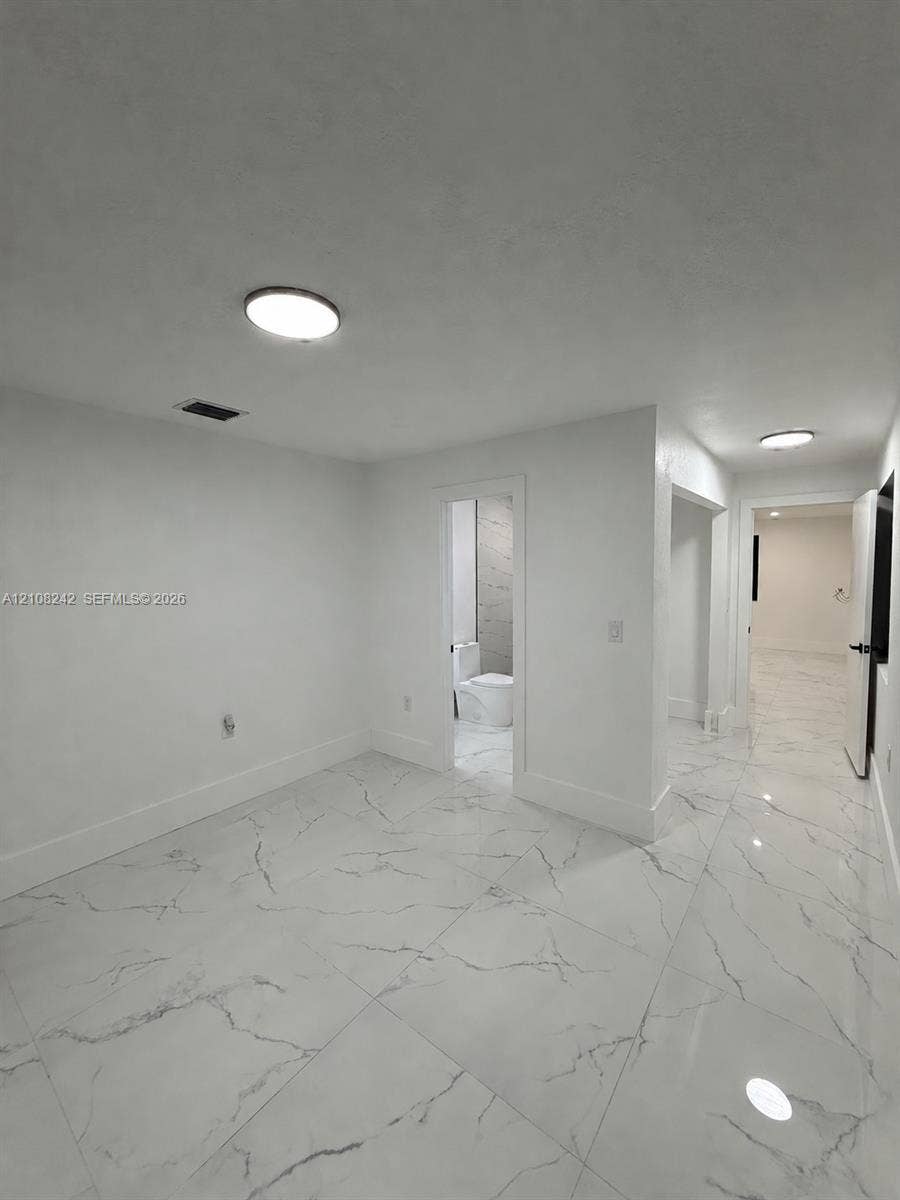 61 E 39th Street, Hialeah, FL 33013 Large-format stone-finish flooring with high-gloss surfacing and flush-mount ceiling light fixtures