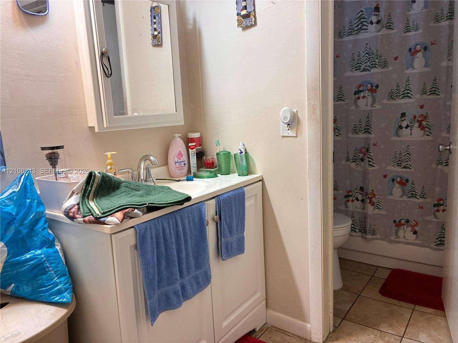 6505 Winfield Boulevard, #B-16, Margate, FL 33063 Bathroom featuring a white vanity cabinet with an integrated sink, a wall-mounted mirrored medicine cabinet, and tile flooring
