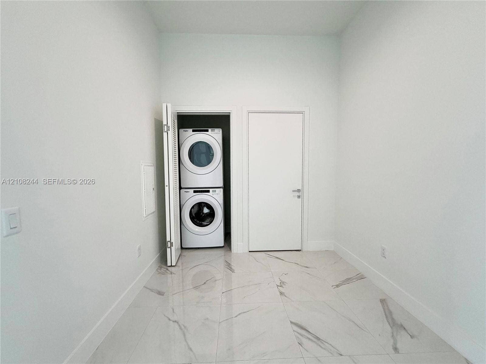 1170 Hallandale Beach Boulevard, #605, Hallandale Beach, Hallandale Beach, FL 33009 Contemporary bathroom featuring a floating white vanity, polished large-format tile flooring, wall-to-wall decorative tile backsplash, and a modern backlit mirror