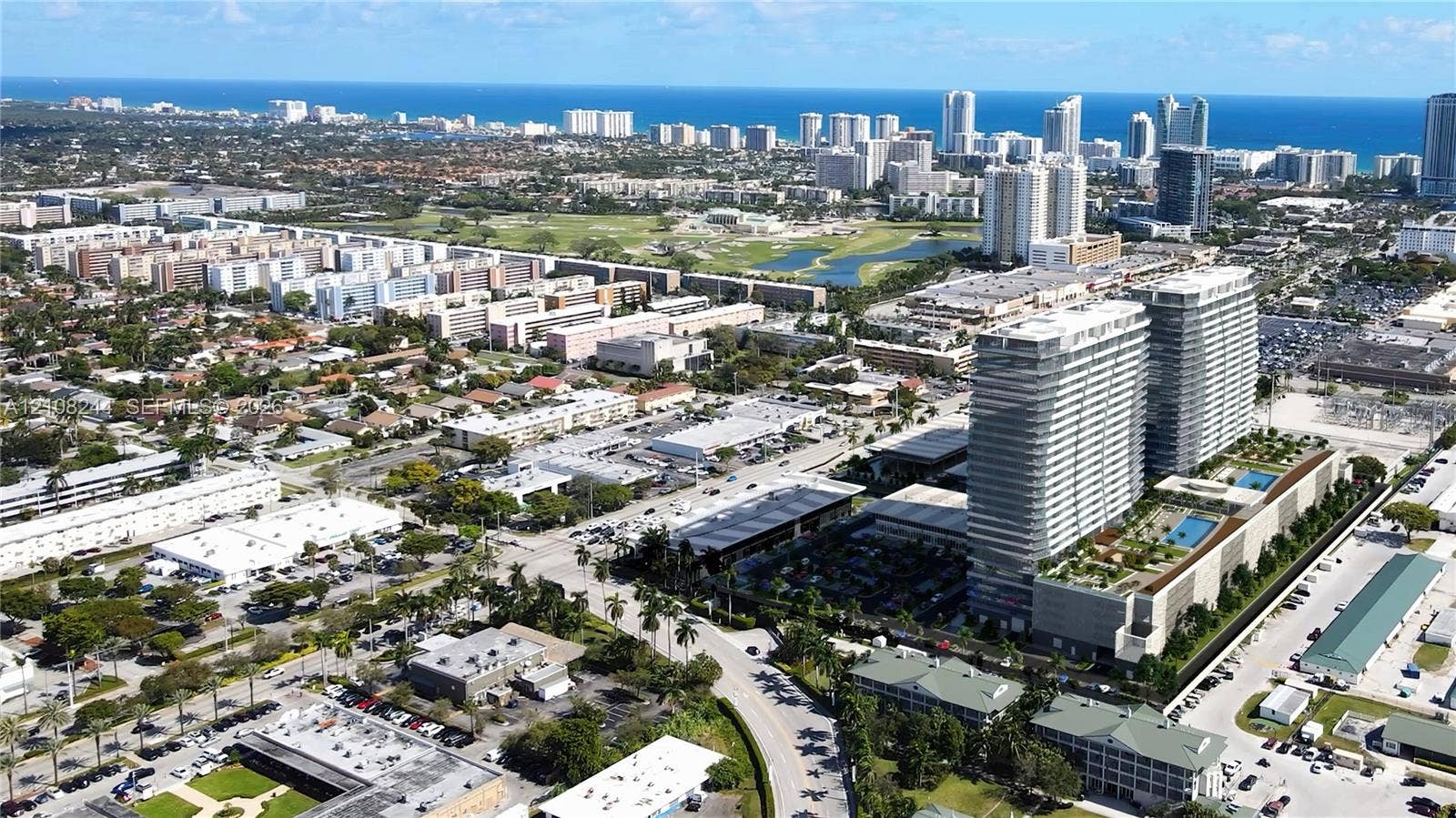 1170 Hallandale Beach Boulevard, #605, Hallandale Beach, Hallandale Beach, FL 33009 Lobby featuring high-gloss tile flooring, floor-to-ceiling windows with full-length drapery, geometric wood-paneled walls with integrated accent lighting, and a metallic reception desk