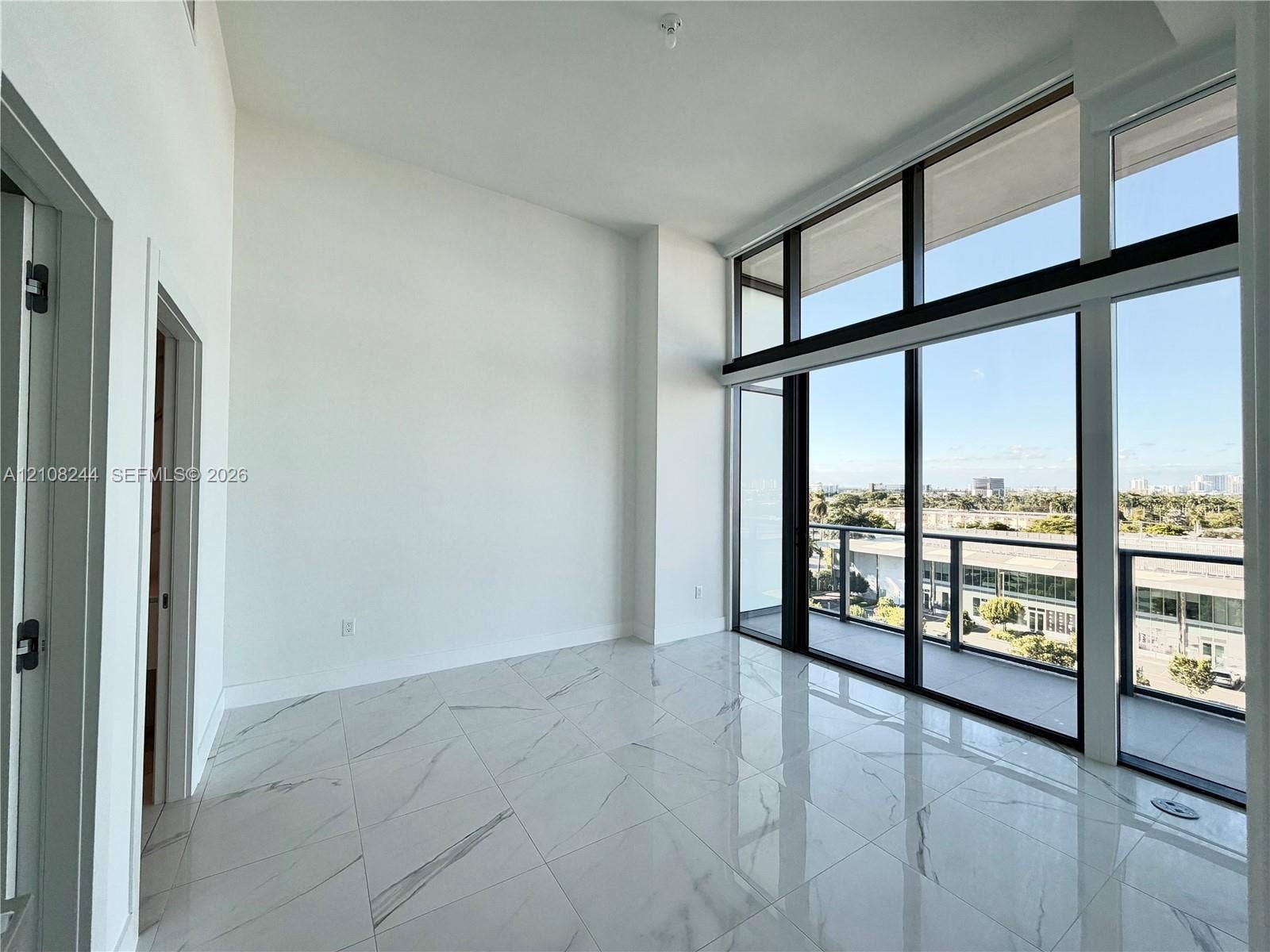 1170 Hallandale Beach Boulevard, #605, Hallandale Beach, Hallandale Beach, FL 33009 Floating double vanity with integrated sinks, full-wall mirror, glass-enclosed soaking tub with shower combination, and large-format porcelain tile wall cladding