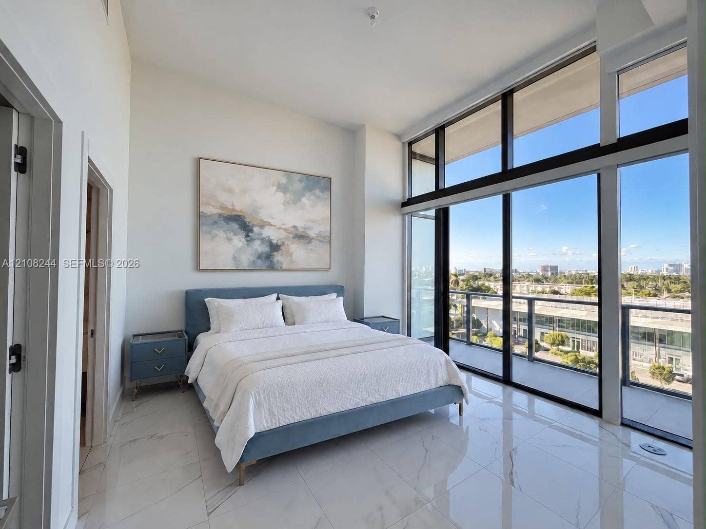 1170 Hallandale Beach Boulevard, #605, Hallandale Beach, Hallandale Beach, FL 33009 High ceilings featuring floor-to-ceiling windows with balcony access and light-toned, vein-patterned tile flooring