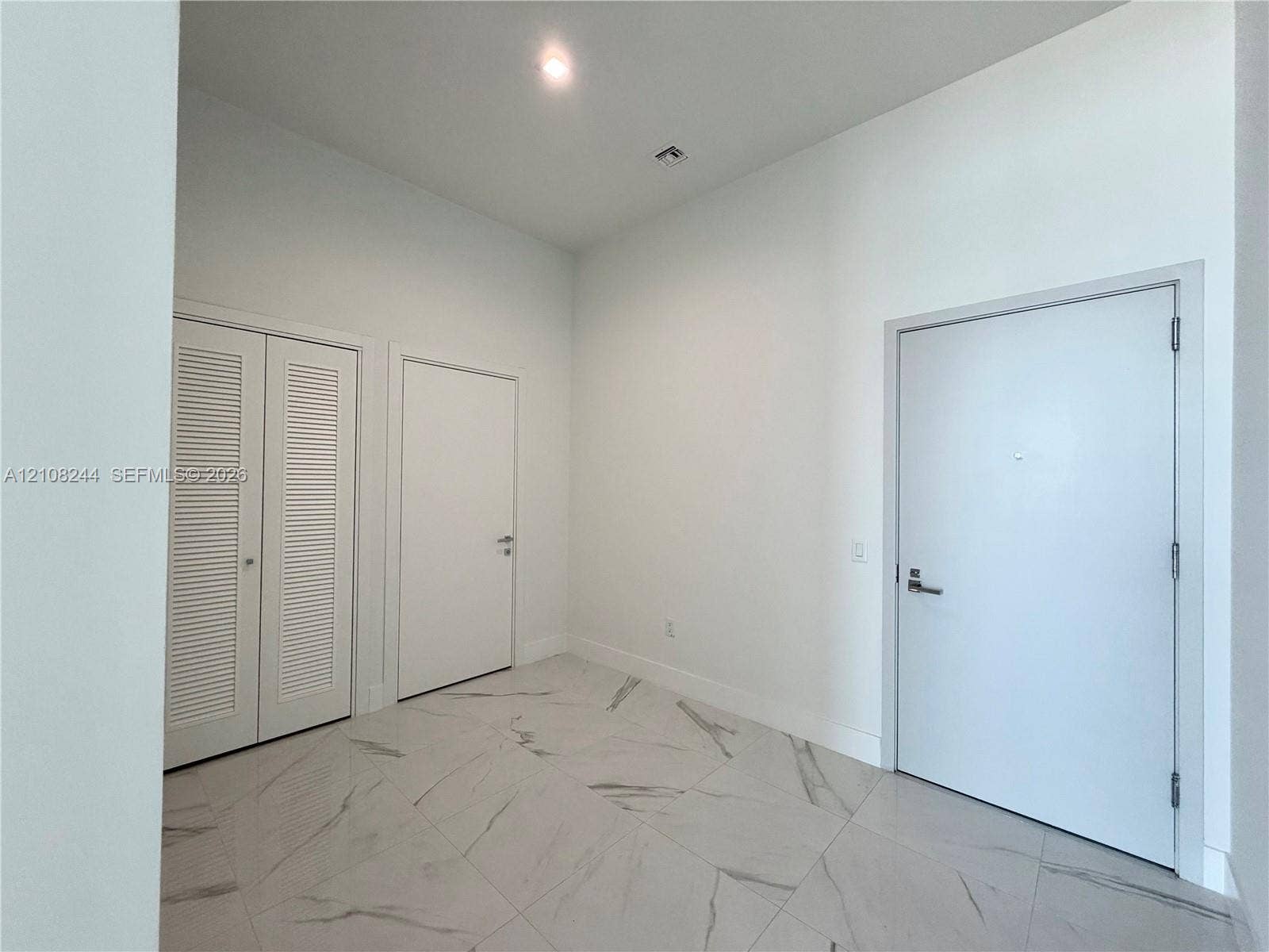 1170 Hallandale Beach Boulevard, #605, Hallandale Beach, Hallandale Beach, FL 33009 Dedicated utility space featuring stone-finish floor tile, a recessed laundry closet, and a stackable washer and dryer unit