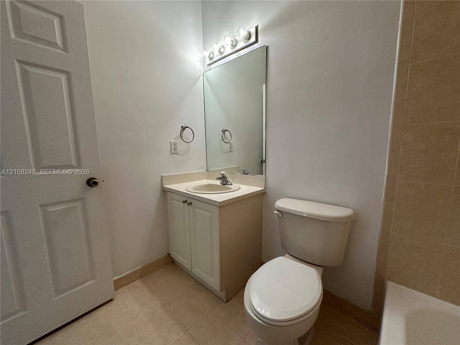2641 NE 4th Street, #204, Homestead, Homestead, FL 33033 Bathroom featuring a vanity with a recessed basin, a large wall-mounted mirror, a multi-bulb vanity light fixture, and tile flooring