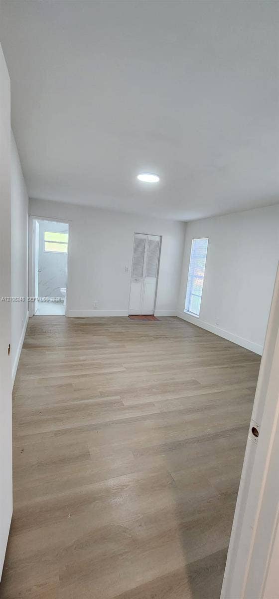4490 Pine Garden Lane, Lake Worth, FL 33467 Room featuring wood-finish flooring, recessed lighting, and vertical windows