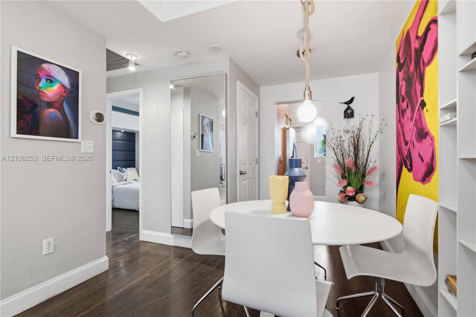 1330 Drexel Avenue, #102, Miami Beach, FL 33139 Dark-stained wood-finish flooring, floor-to-ceiling wall mirror, recessed ceiling lighting, rope-suspended pendant light, and built-in shelving unit