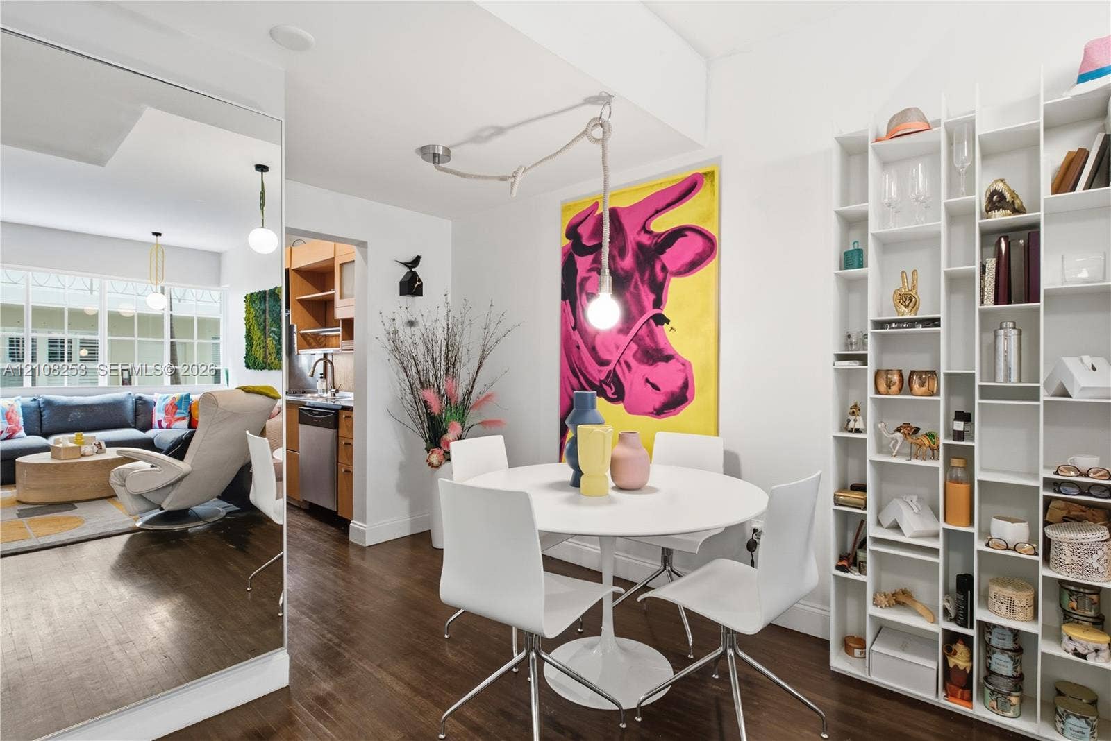 1330 Drexel Avenue, #102, Miami Beach, FL 33139 Floor-to-ceiling wall mirror, built-in floor-to-ceiling white shelving unit, and dark wood-finish flooring