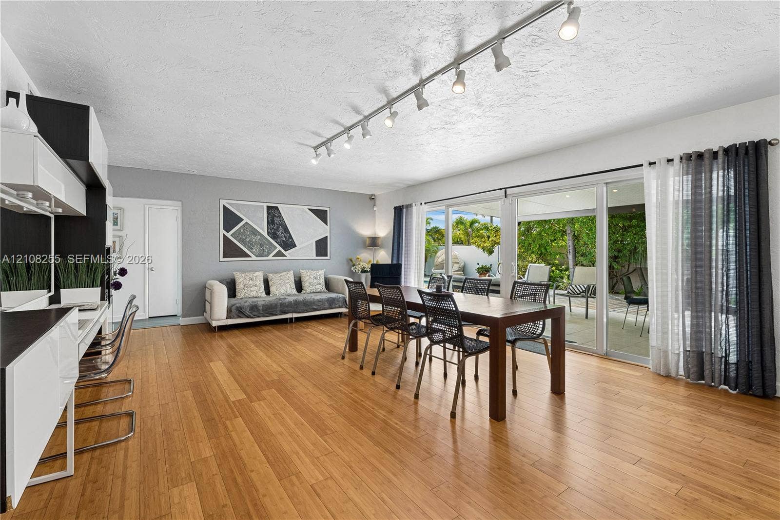 1650 NE 171st Street, North Miami Beach, North Miami Beach, FL 33162 Living space featuring wood-finish flooring, ceiling-mounted track lighting, and expansive sliding glass doors