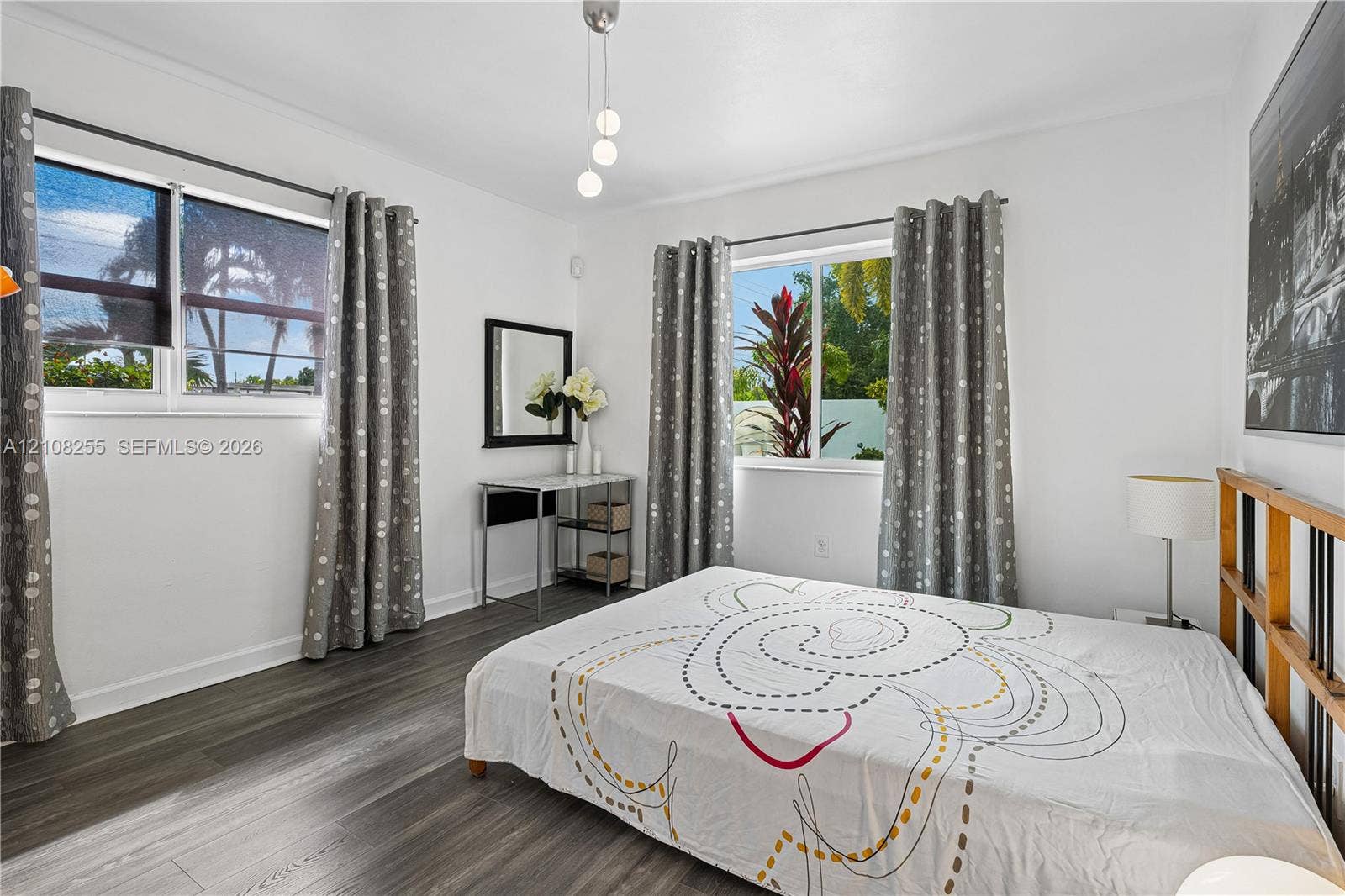 1650 NE 171st Street, North Miami Beach, North Miami Beach, FL 33162 Bedroom featuring wood-finish flooring, dual windows, and a multi-pendant light fixture