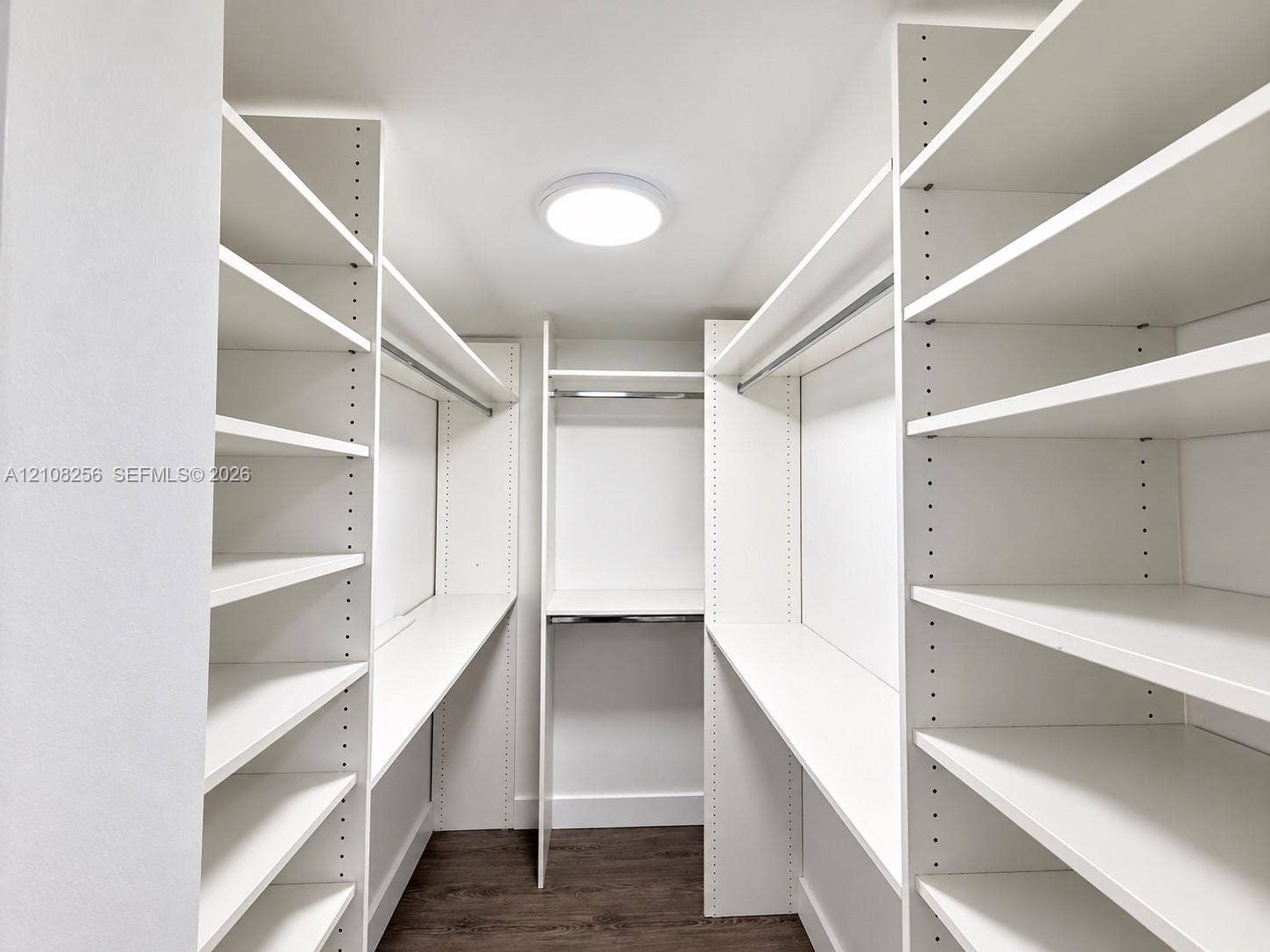 9350 Fontainebleau Boulevard, #110, Miami, Miami, FL 33172 Walk-in storage space featuring floor-to-ceiling white custom shelving, hanging rods, and dark wood-finish flooring