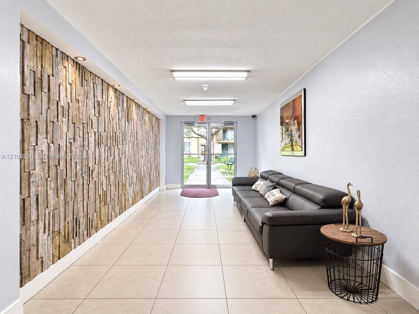 9350 Fontainebleau Boulevard, #110, Miami, Miami, FL 33172 Entrance lobby featuring a textured wood-plank accent wall, large-format tile flooring, and recessed ceiling lighting