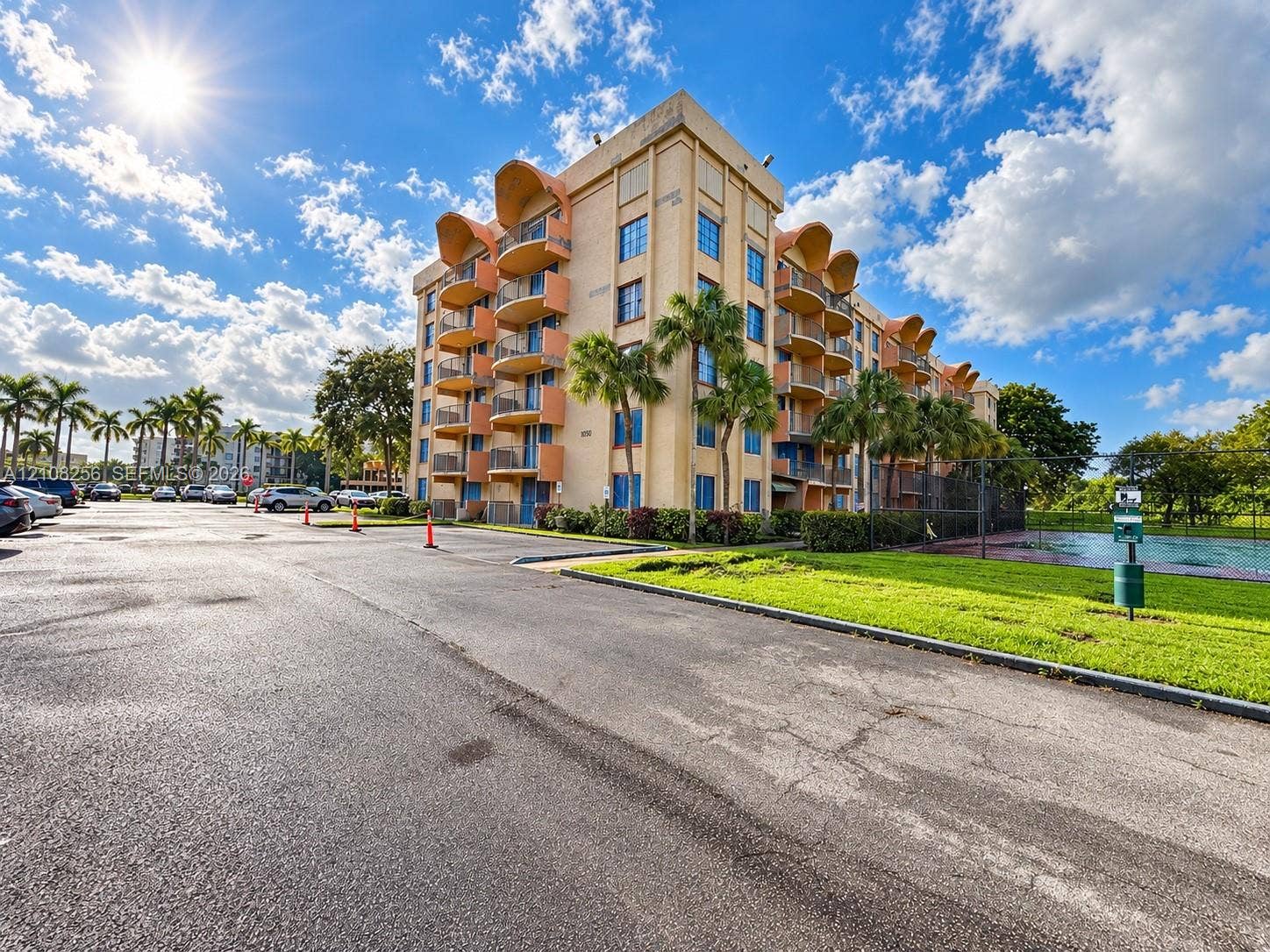 9350 Fontainebleau Boulevard, #110, Miami, Miami, FL 33172 Multi-story stucco exterior featuring arched balconies, metallic railings, paved parking area, and landscaped grounds