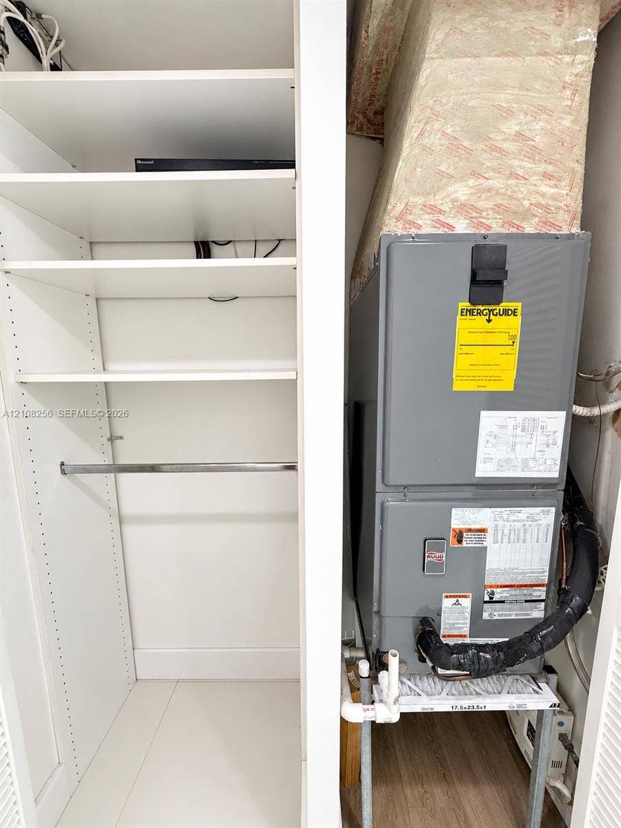 9350 Fontainebleau Boulevard, #110, Miami, Miami, FL 33172 Built-in white shelving with a metal hanging rod and a utility closet containing a mechanical HVAC system