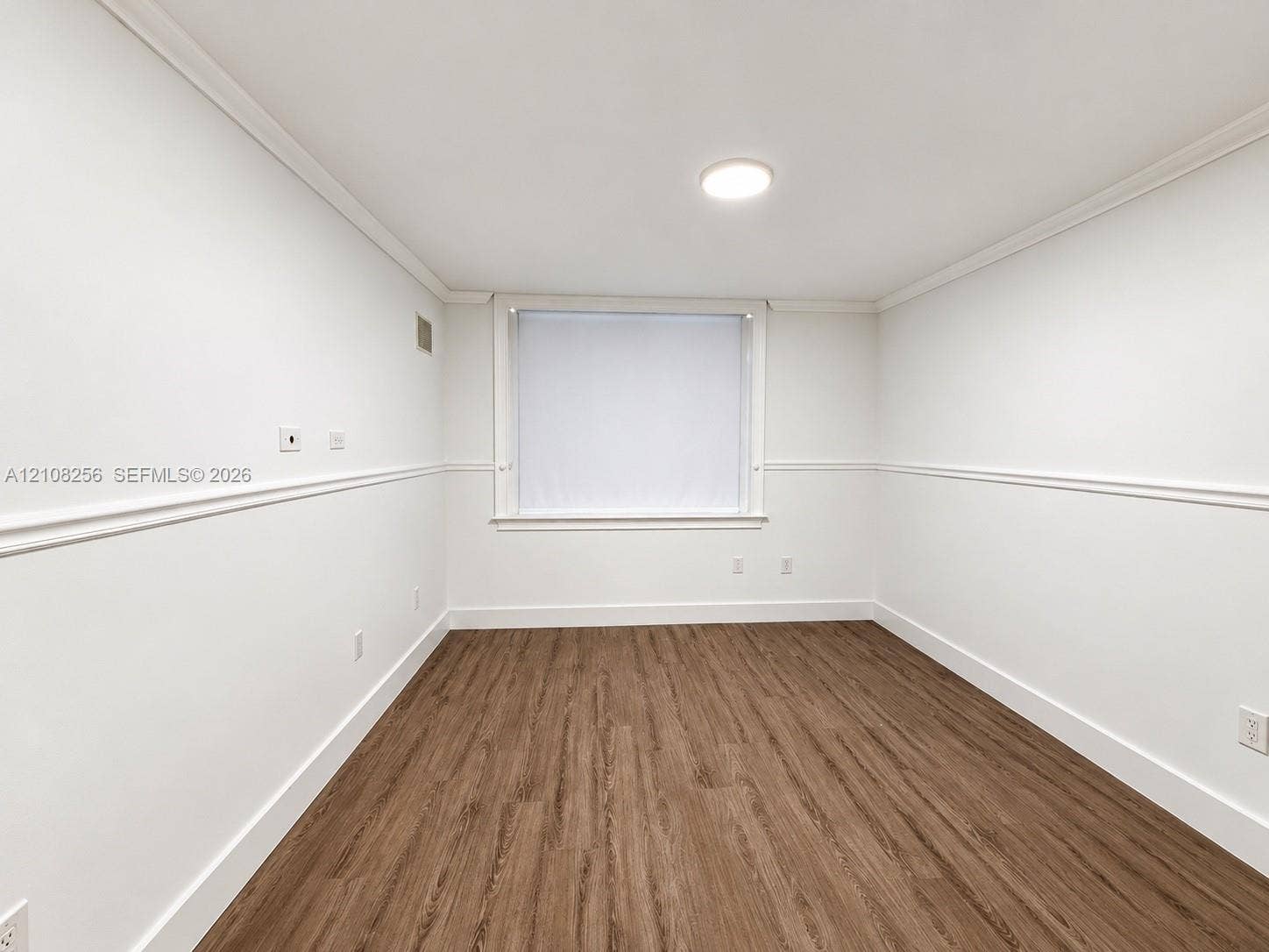 9350 Fontainebleau Boulevard, #110, Miami, Miami, FL 33172 Room featuring wood-finish flooring, white walls with chair rail molding, and a flush-mount ceiling light