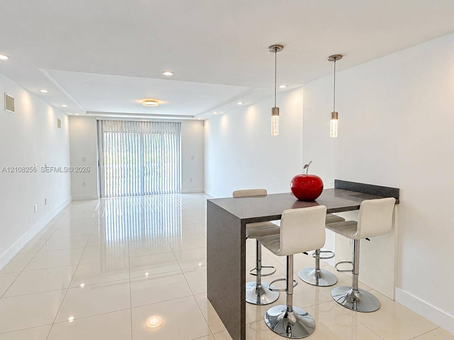 9350 Fontainebleau Boulevard, #110, Miami, Miami, FL 33172 Open-concept interior featuring large-format tile flooring, recessed ceiling lighting, dual cylinder pendant lights, and a waterfall-edge breakfast bar with a solid surface countertop