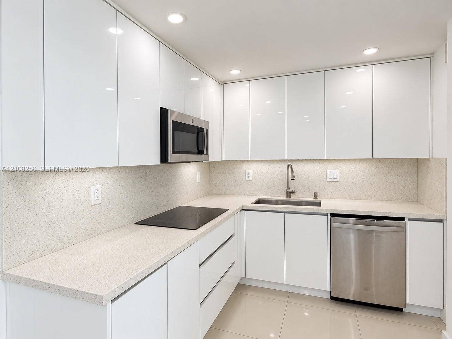 9350 Fontainebleau Boulevard, #110, Miami, Miami, FL 33172 Kitchen featuring flat-panel white cabinetry, stone-surface countertops, integrated stainless steel appliances, recessed lighting, and large-format tile flooring