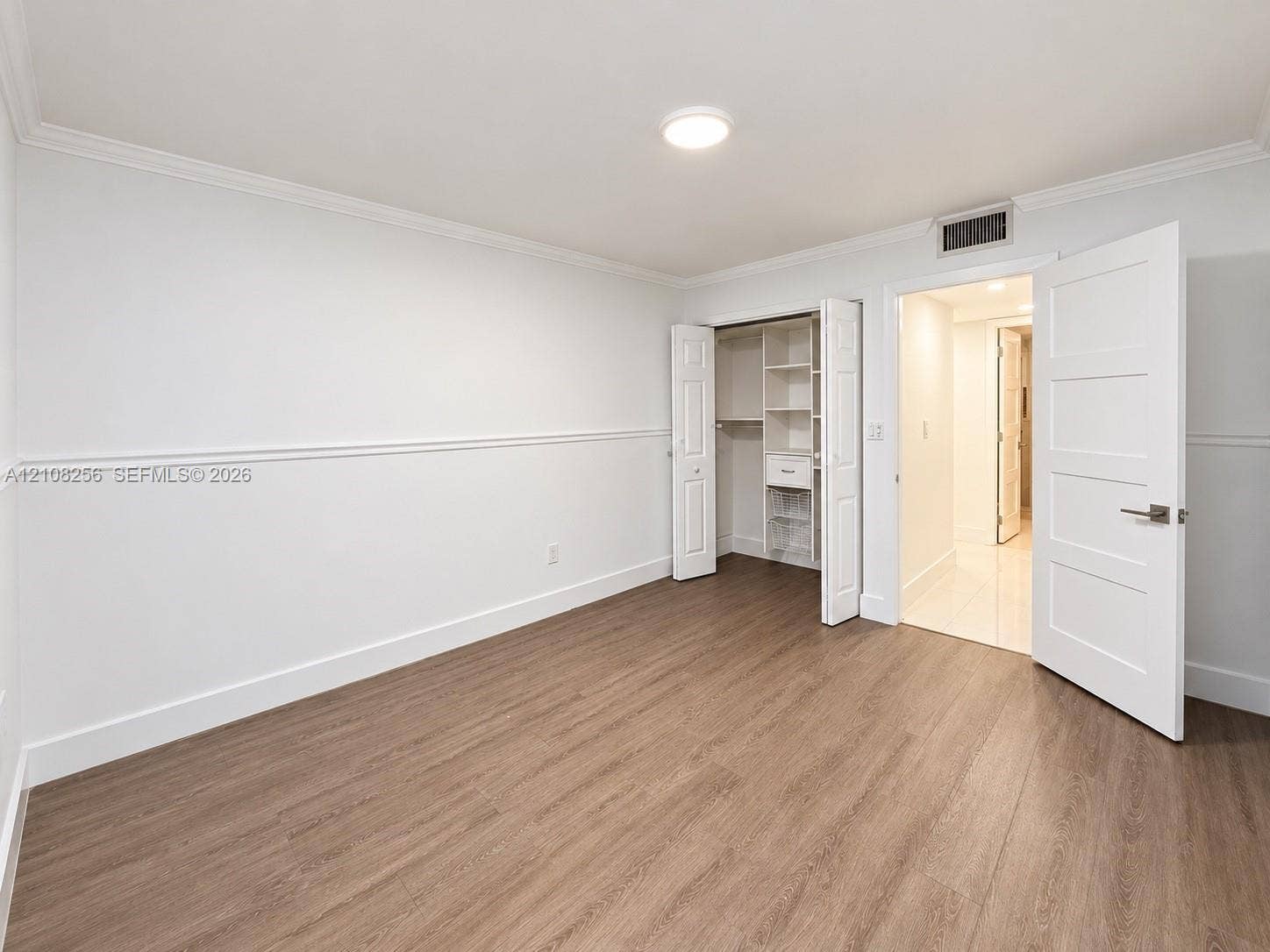 9350 Fontainebleau Boulevard, #110, Miami, Miami, FL 33172 Wood-finish flooring, white walls with chair rail molding, and a closet with built-in shelving