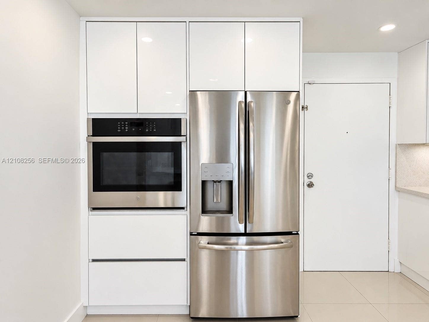 9350 Fontainebleau Boulevard, #110, Miami, Miami, FL 33172 Kitchen featuring floor-to-ceiling high-gloss white cabinetry, integrated stainless steel wall oven, and French-door stainless steel refrigerator