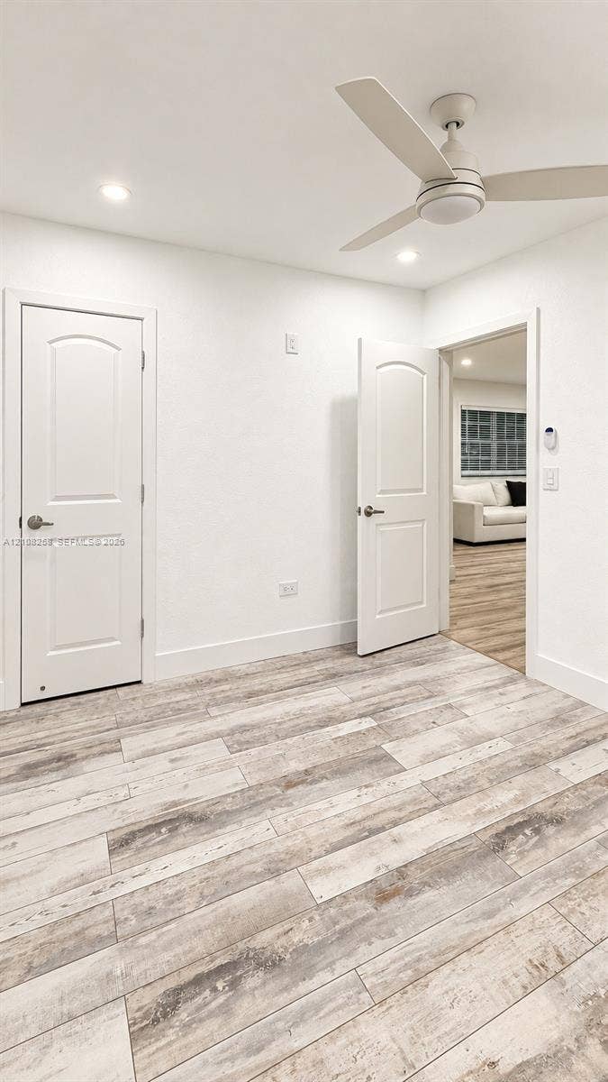 909 NE 111th Street, #909, Biscayne Park, Biscayne Park, FL 33161 Wood-finish flooring, three-blade ceiling fan with integrated light, and two-panel interior doors with brushed nickel hardware