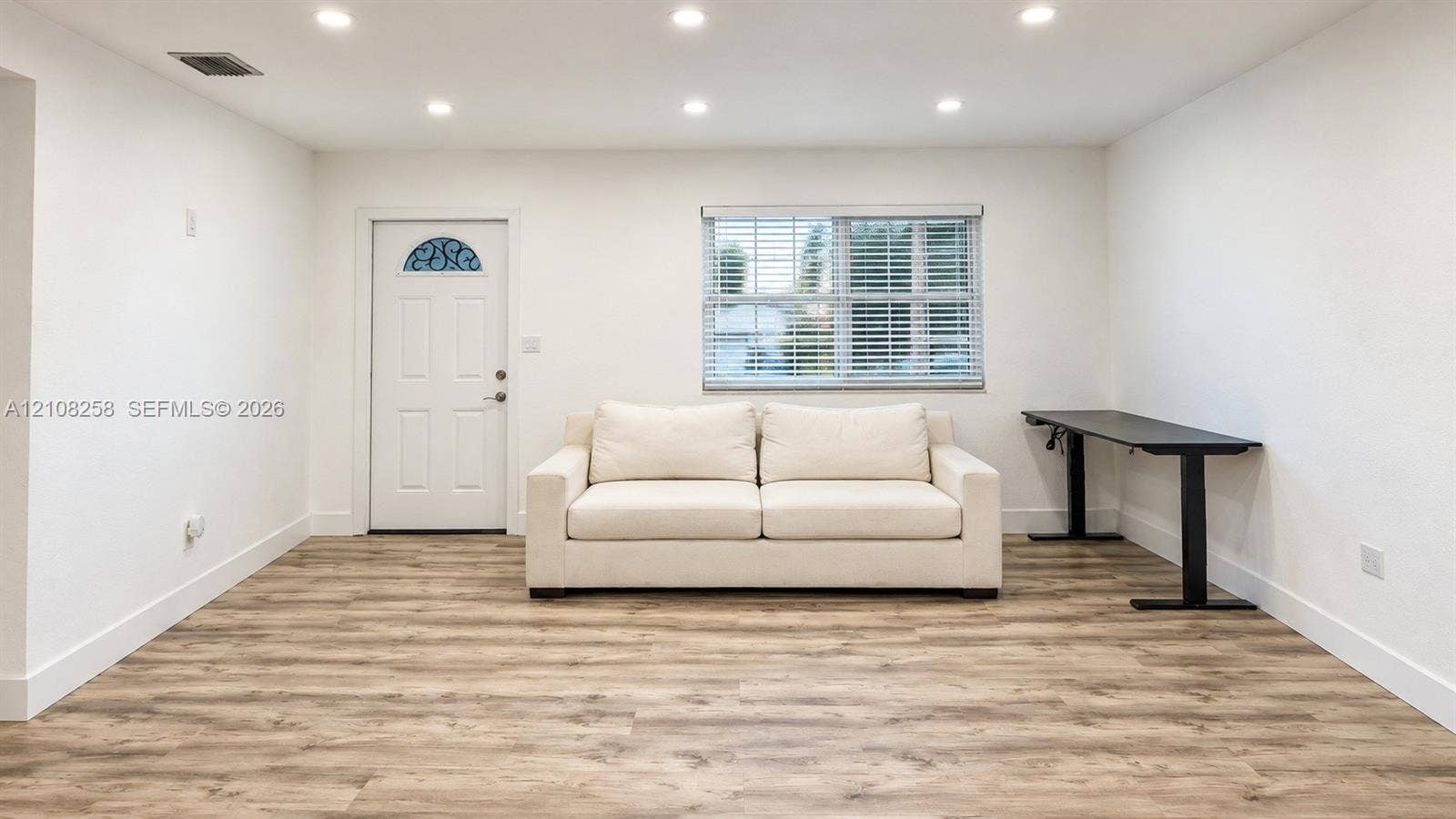 909 NE 111th Street, #909, Biscayne Park, Biscayne Park, FL 33161 Neutral wall palette with wood-finish flooring, recessed ceiling lighting, and a single-entry door with an arched decorative glass insert