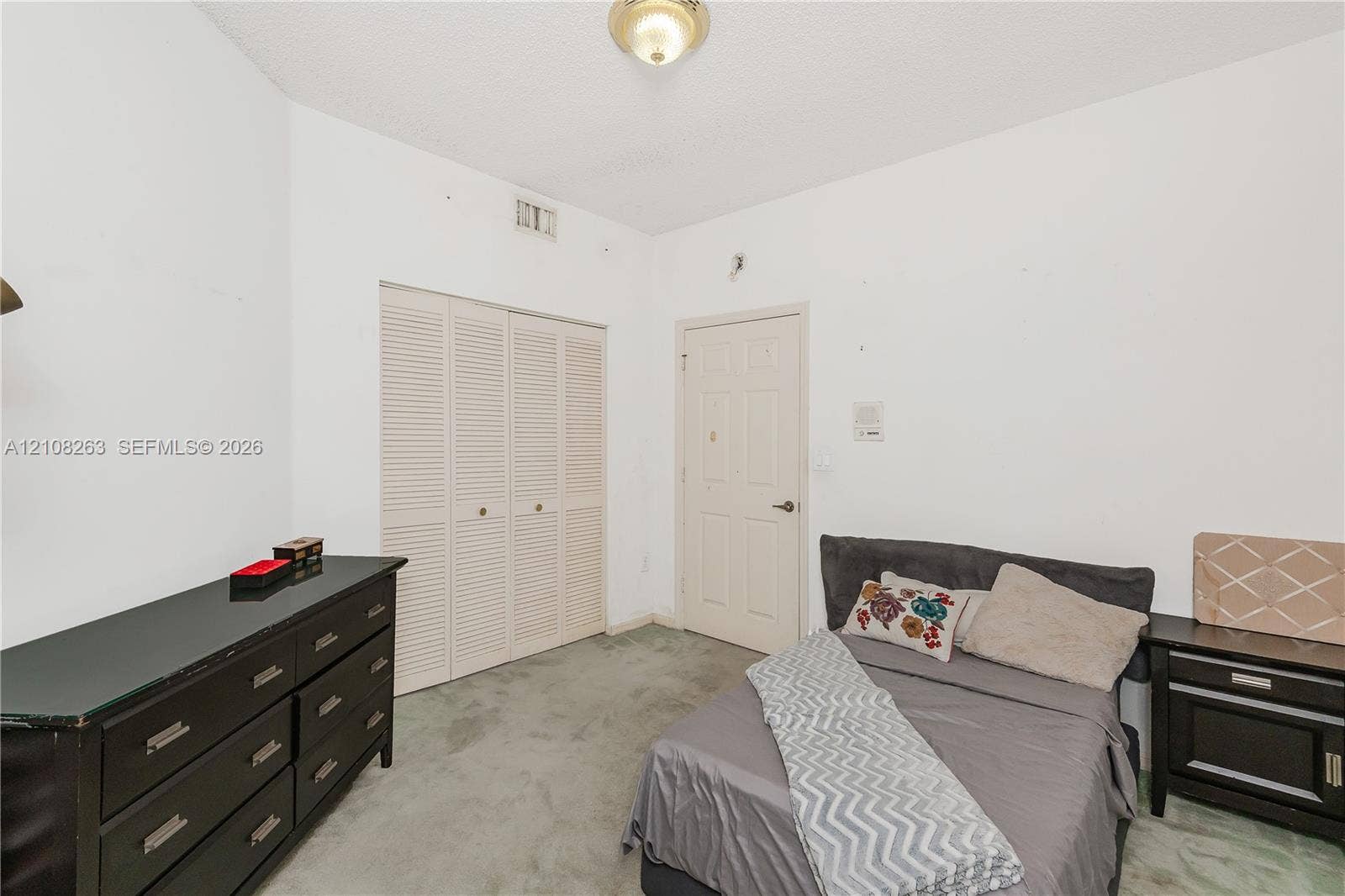 14817 Balgowan Road, #102-5, Miami Lakes, FL 33016 Room featuring carpeting, bifold closet doors, a paneled interior door, and a flush-mount ceiling light fixture