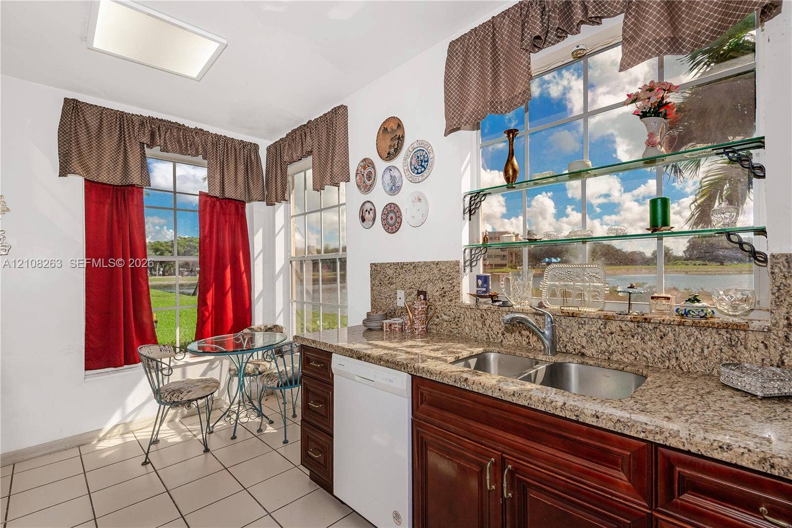 14817 Balgowan Road, #102-5, Miami Lakes, FL 33016 Kitchen featuring stone-finish countertops, stainless steel dual-basin undermount sink, dark-finish cabinetry, tile flooring, and multiple large windows