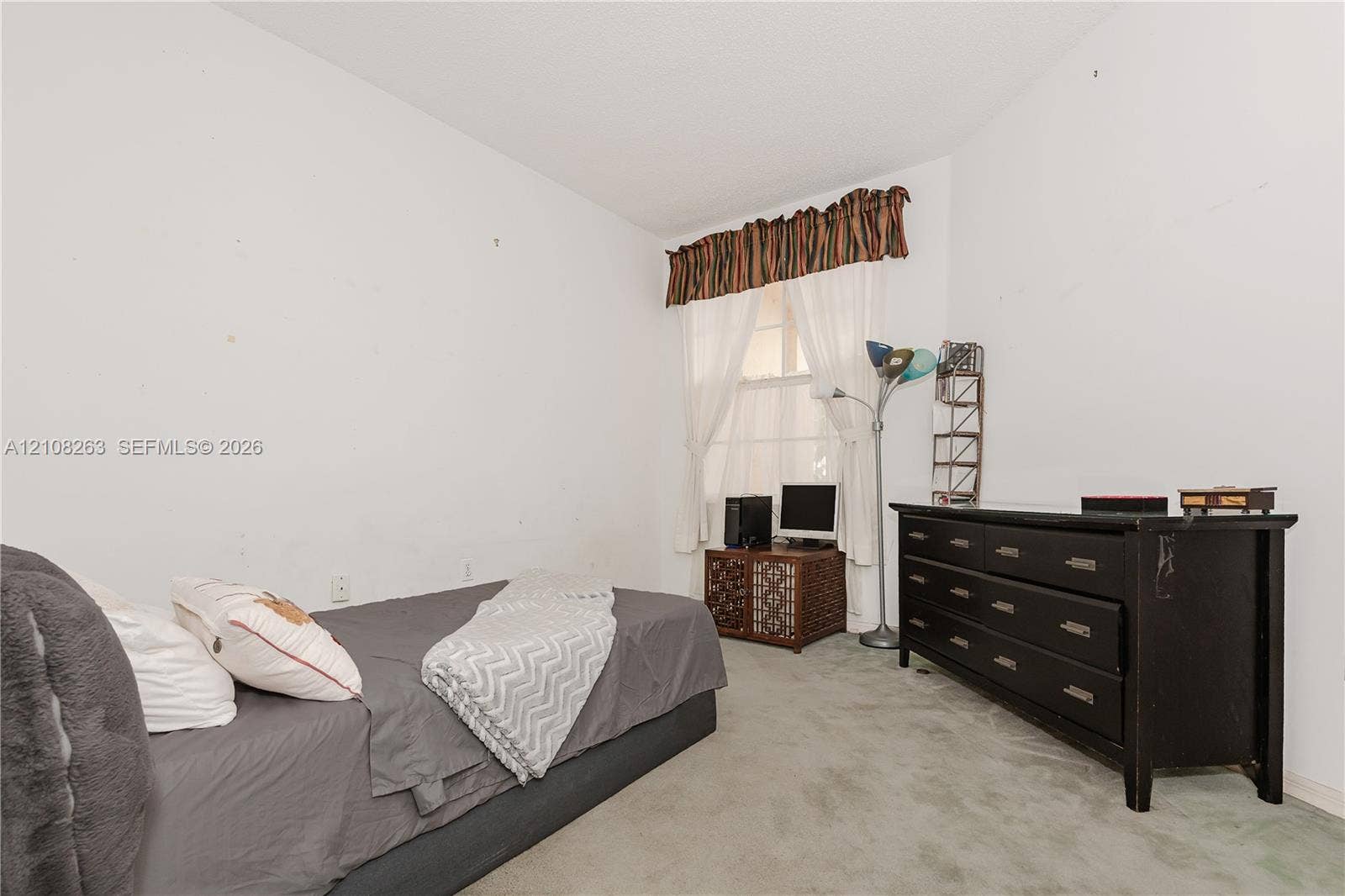 14817 Balgowan Road, #102-5, Miami Lakes, FL 33016 Interior room featuring neutral wall finishes, wall-to-wall carpeting, and a window with a fabric valance