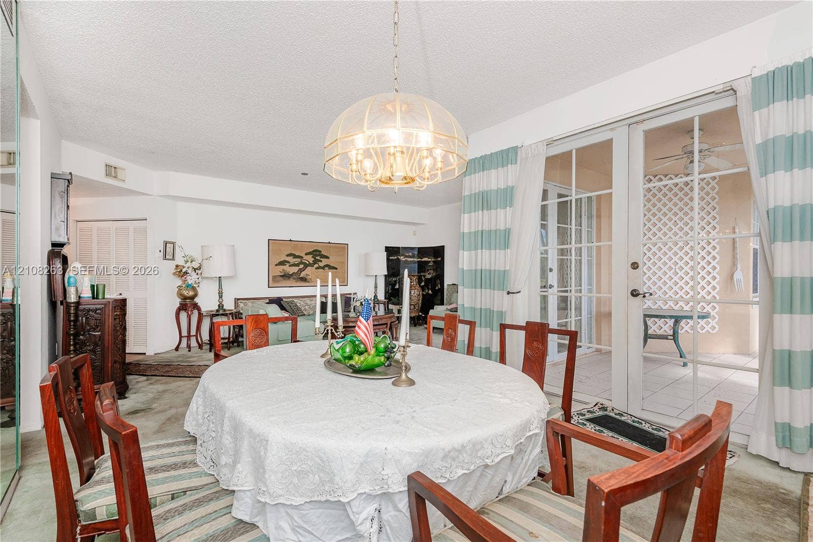14817 Balgowan Road, #102-5, Miami Lakes, FL 33016 Dining space featuring a multi-tiered glass dome chandelier and glass-paned sliding doors opening to an exterior patio