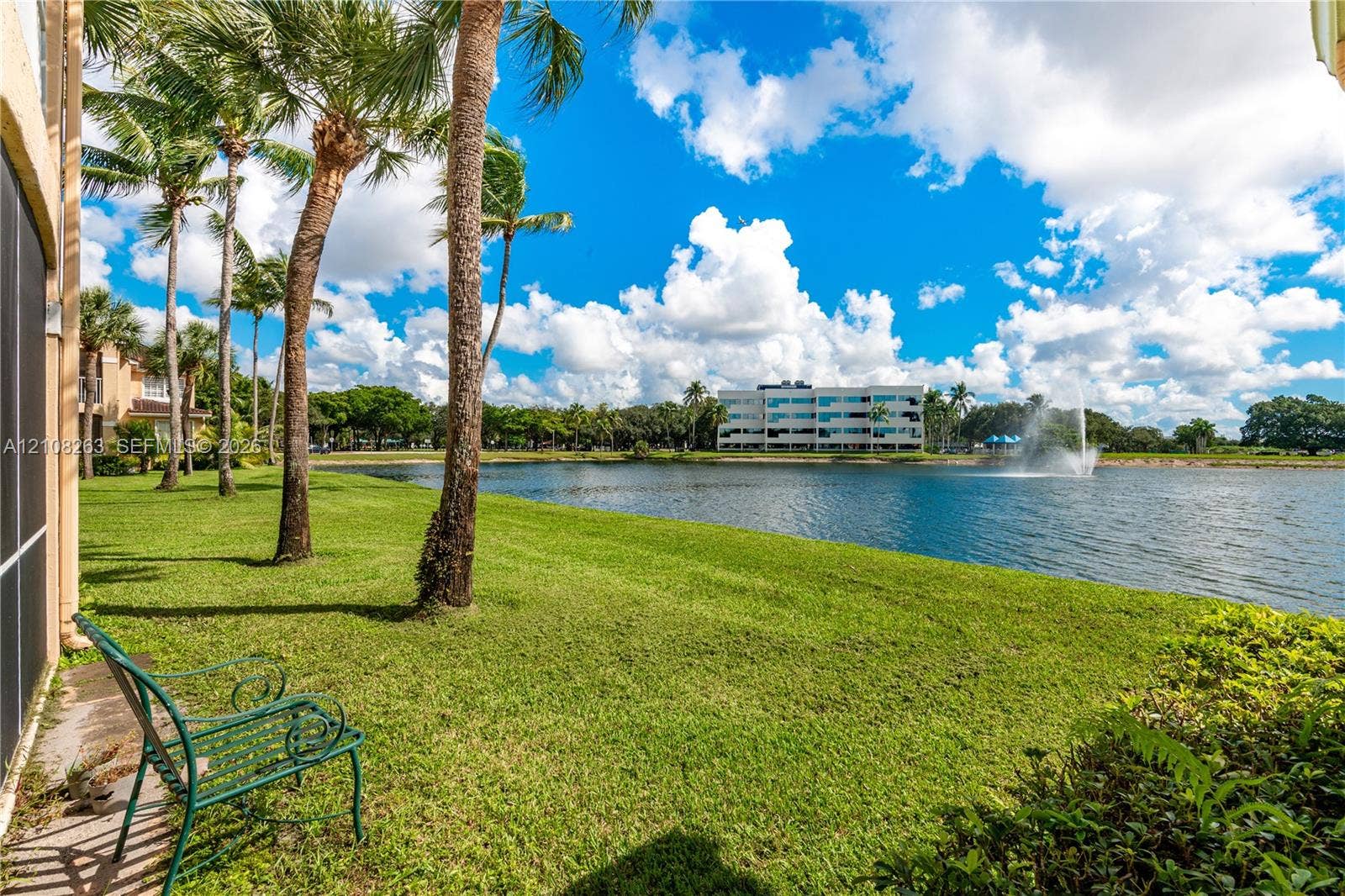 14817 Balgowan Road, #102-5, Miami Lakes, FL 33016 Waterfront lawn featuring mature palm trees and a fountain