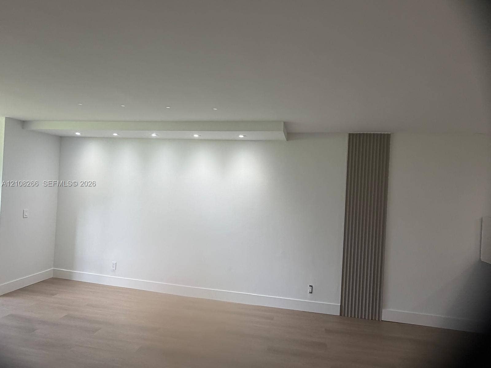 9721 Sunrise Lakes Boulevard, #108, Sunrise, FL 33322 Minimalist interior featuring recessed ceiling lighting, light-toned wood-finish flooring, and a decorative vertical slat accent wall