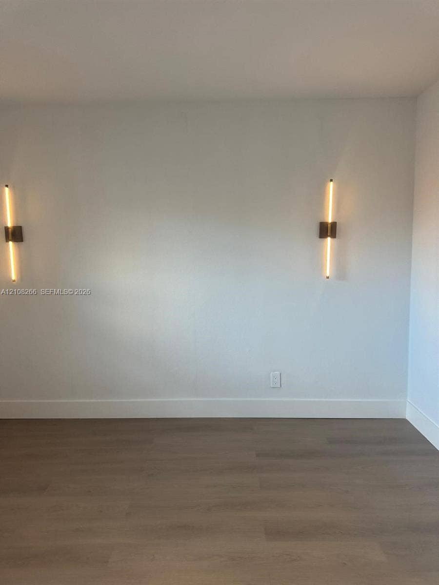 9721 Sunrise Lakes Boulevard, #108, Sunrise, FL 33322 Wood-finish flooring paired with two contemporary linear wall-mounted light fixtures