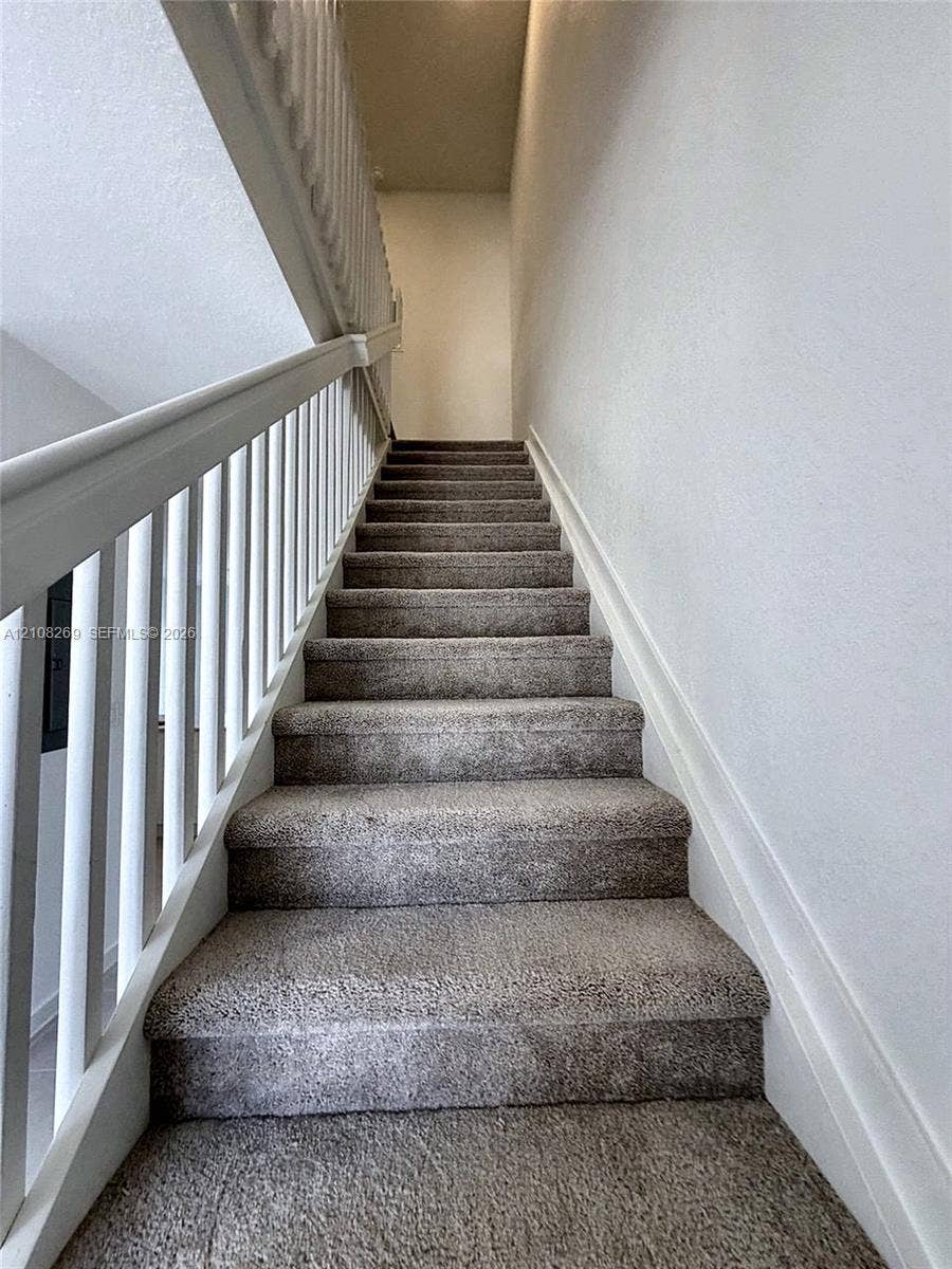 2593 SE 25th Drive, Homestead, Homestead, FL 33035 Staircase featuring wall-to-wall carpeting, white wooden balusters, and a matching handrail