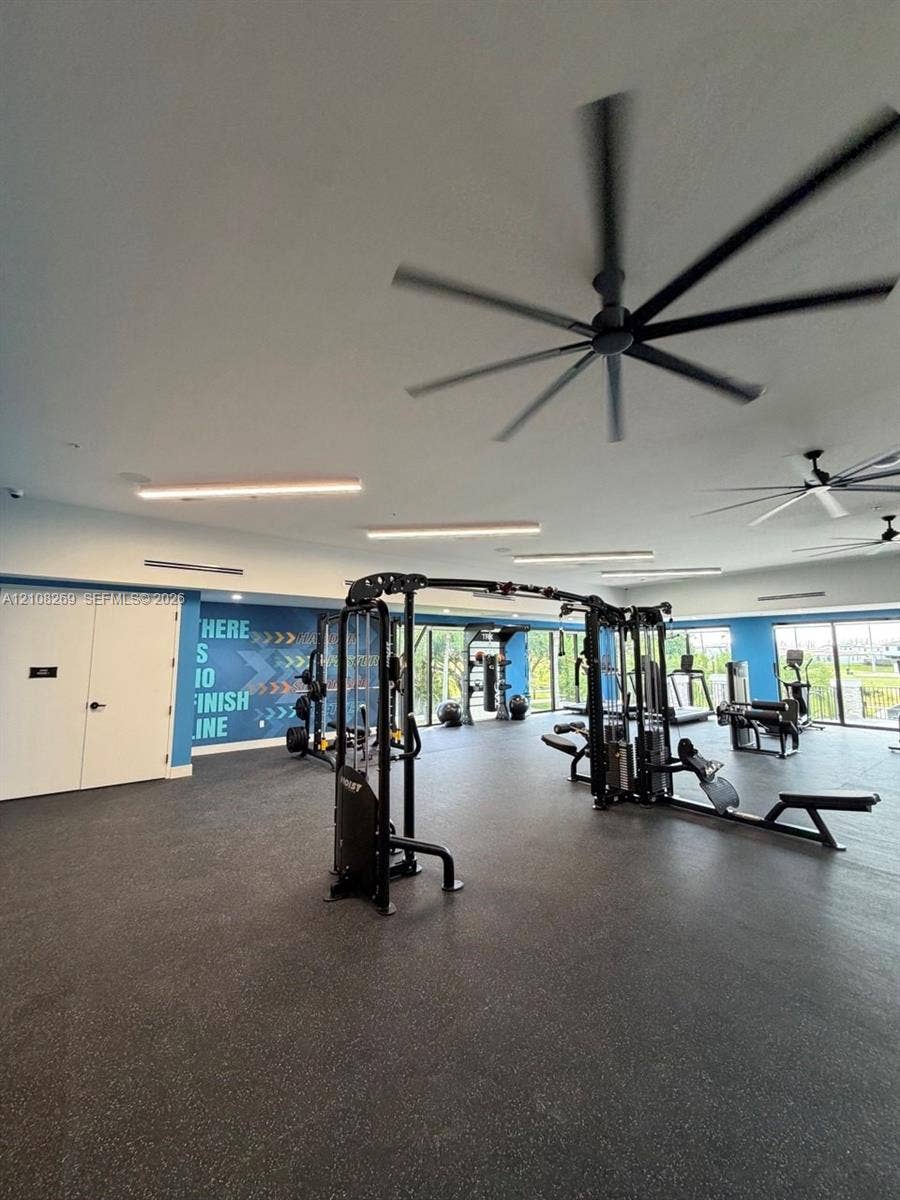 2593 SE 25th Drive, Homestead, Homestead, FL 33035 Fitness center featuring high-contrast rubberized flooring, large-diameter ceiling fans, linear recessed lighting, and floor-to-ceiling windows
