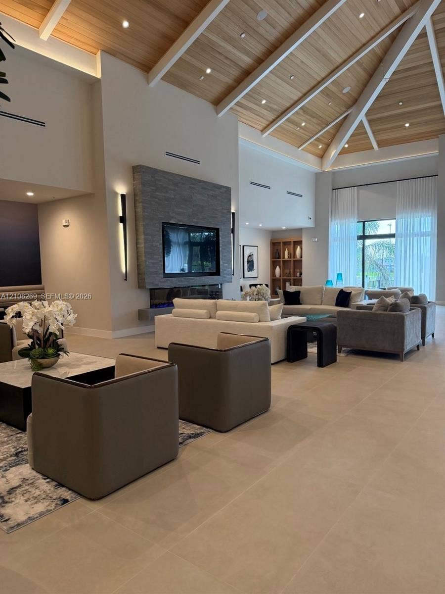 2593 SE 25th Drive, Homestead, Homestead, FL 33035 Vaulted ceiling with wood-finish paneling and exposed beams, stacked stone fireplace surround, recessed lighting, and large-format tile flooring
