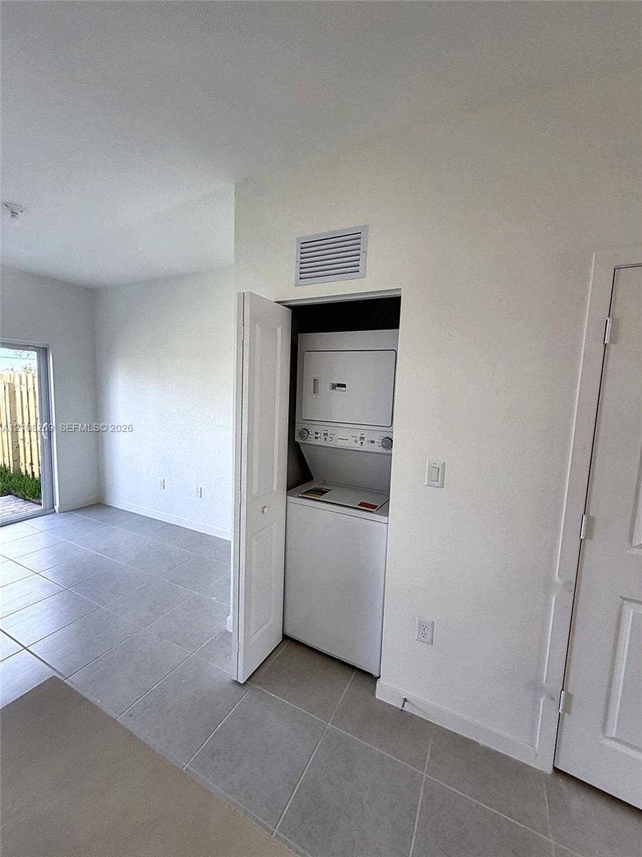 2593 SE 25th Drive, Homestead, Homestead, FL 33035 Closet-housed stacked laundry unit with ceramic tile flooring and neutral-toned wall finishes