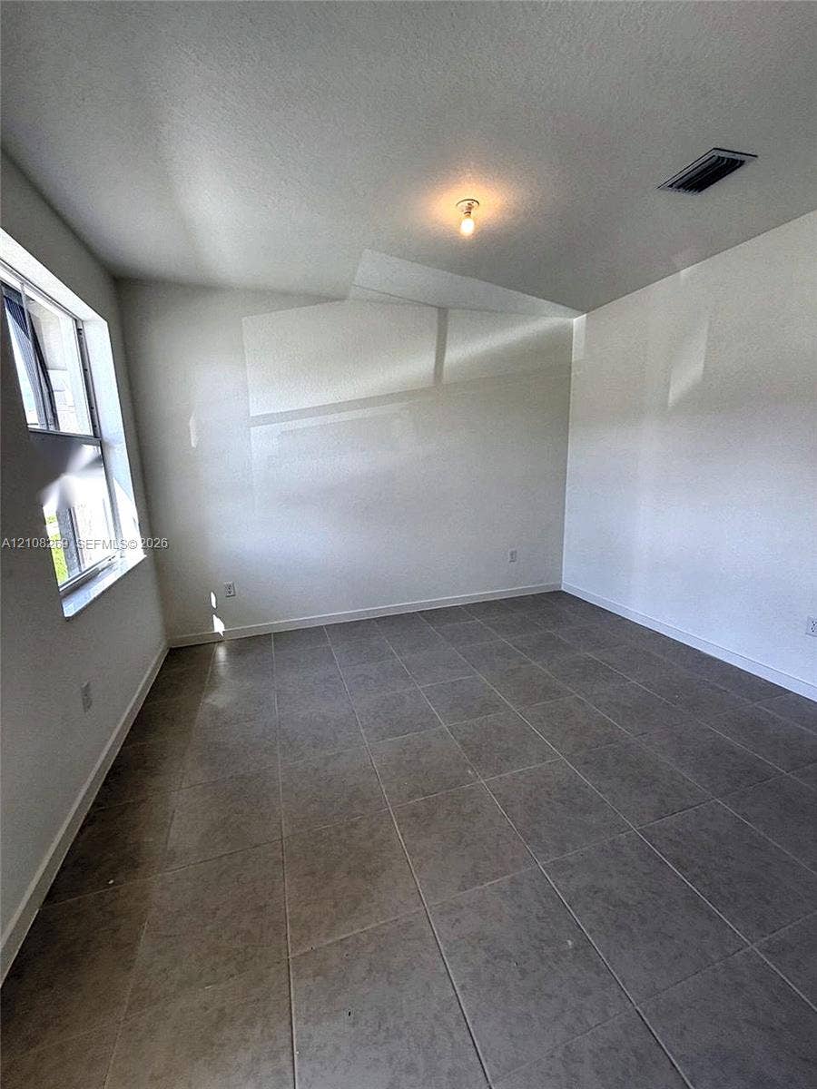 2593 SE 25th Drive, Homestead, Homestead, FL 33035 Neutral-toned tile flooring, tall windows providing natural light, and a central ceiling light fixture