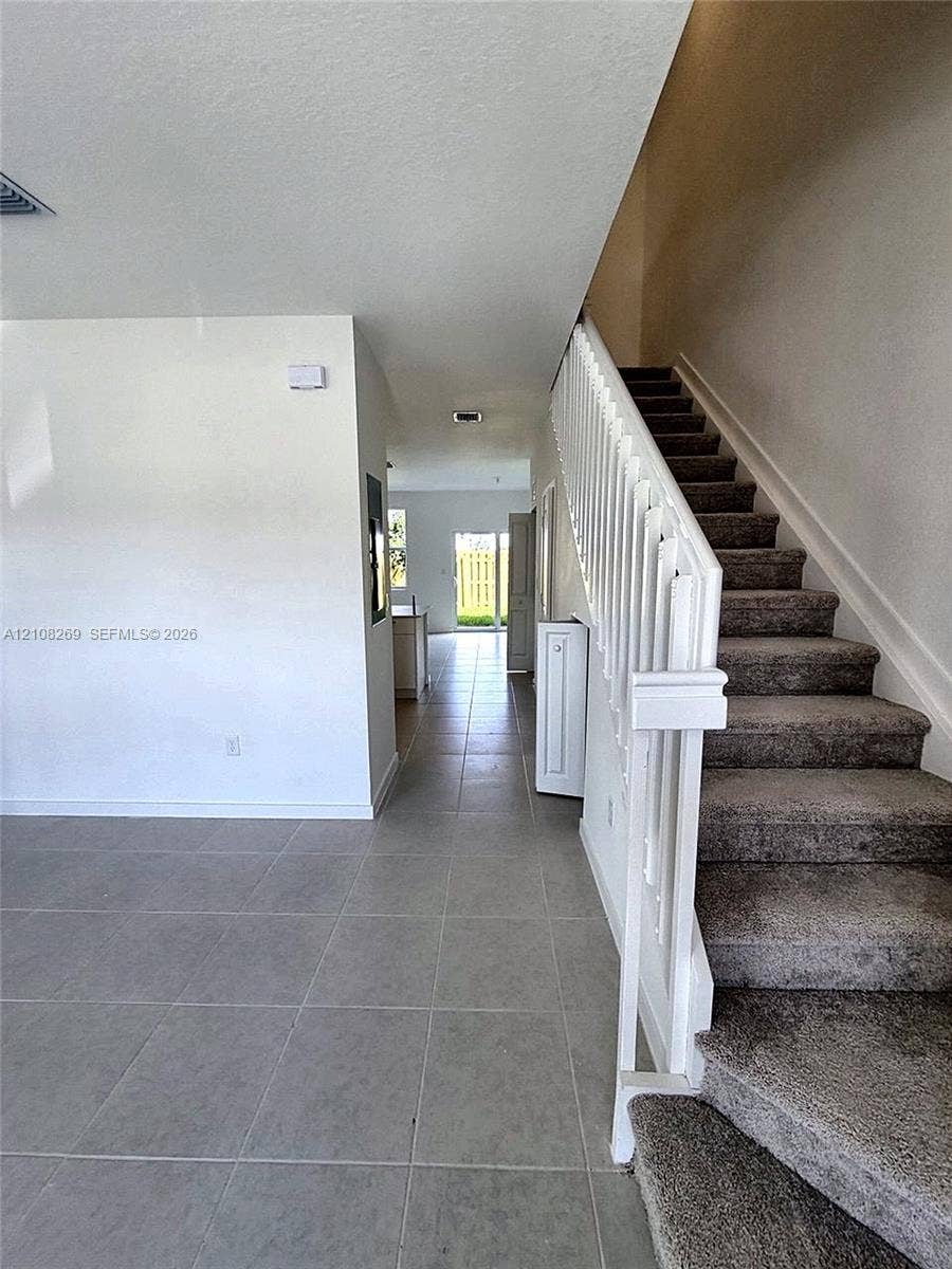 2593 SE 25th Drive, Homestead, Homestead, FL 33035 Large-format tile flooring, staircase with white railing, and neutral wall finish