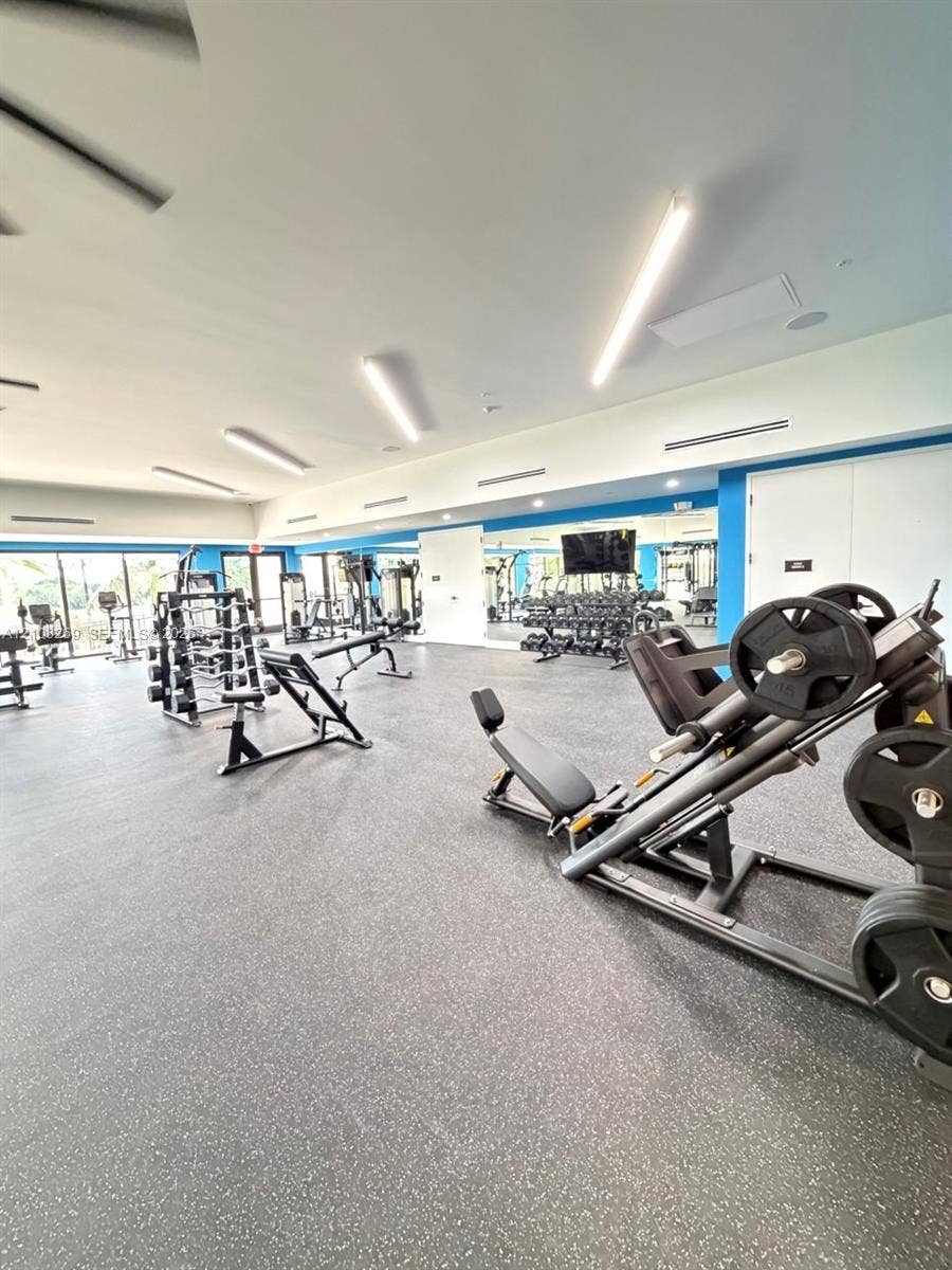 2593 SE 25th Drive, Homestead, Homestead, FL 33035 Fitness center featuring durable rubberized flooring, linear LED lighting, and expansive wall-to-wall mirrors