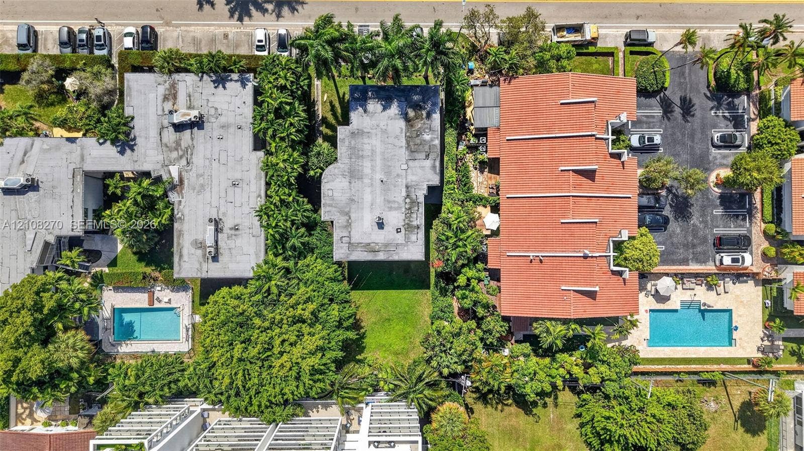 1125 99th Street, #12, Bay Harbor Islands, FL 33154 Aerial perspective showcasing a parcel of land with established green space, mature canopy trees, lush landscaping, and integrated paved parking